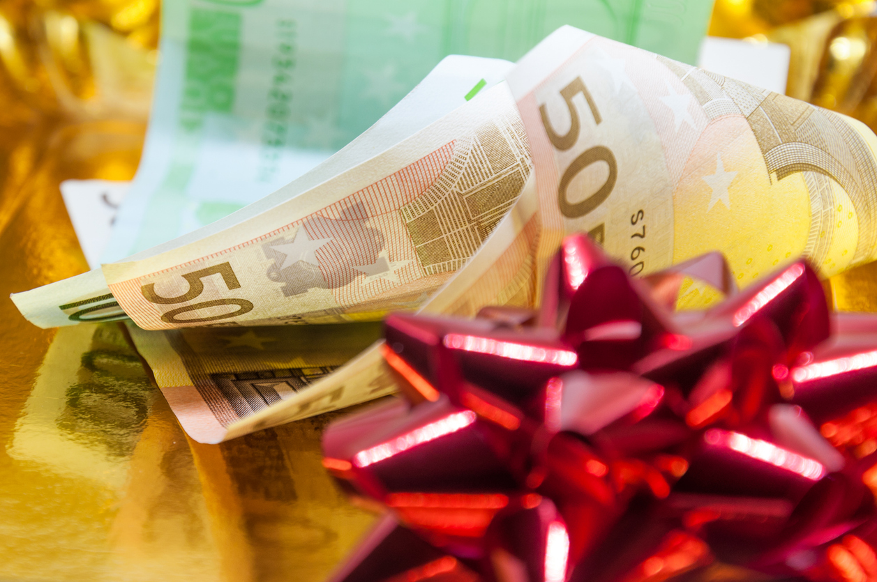 Money with a red gift bow on golden background