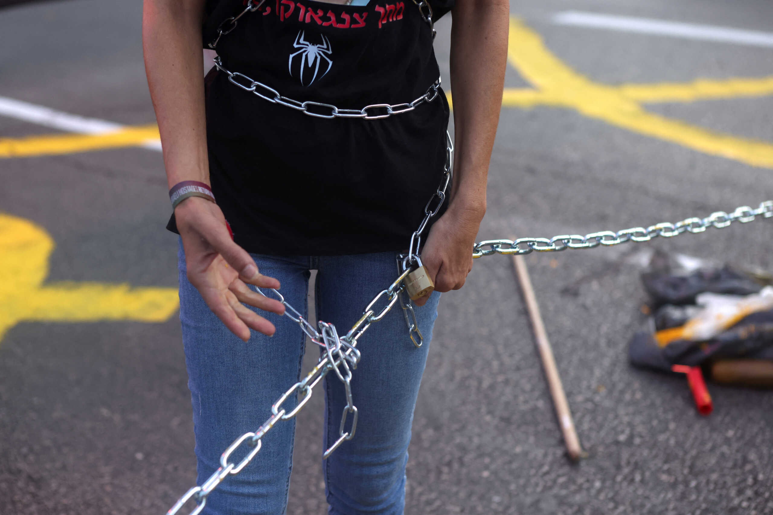 A demonstrator wraps a chain around herself as people block traffic on the road during a protest against the government and to show support for the hostages who were kidnapped during the deadly October 7 attack, amid the ongoing conflict in Gaza between Israel and Hamas, in Tel Aviv, Israel September 13, 2024. REUTERS