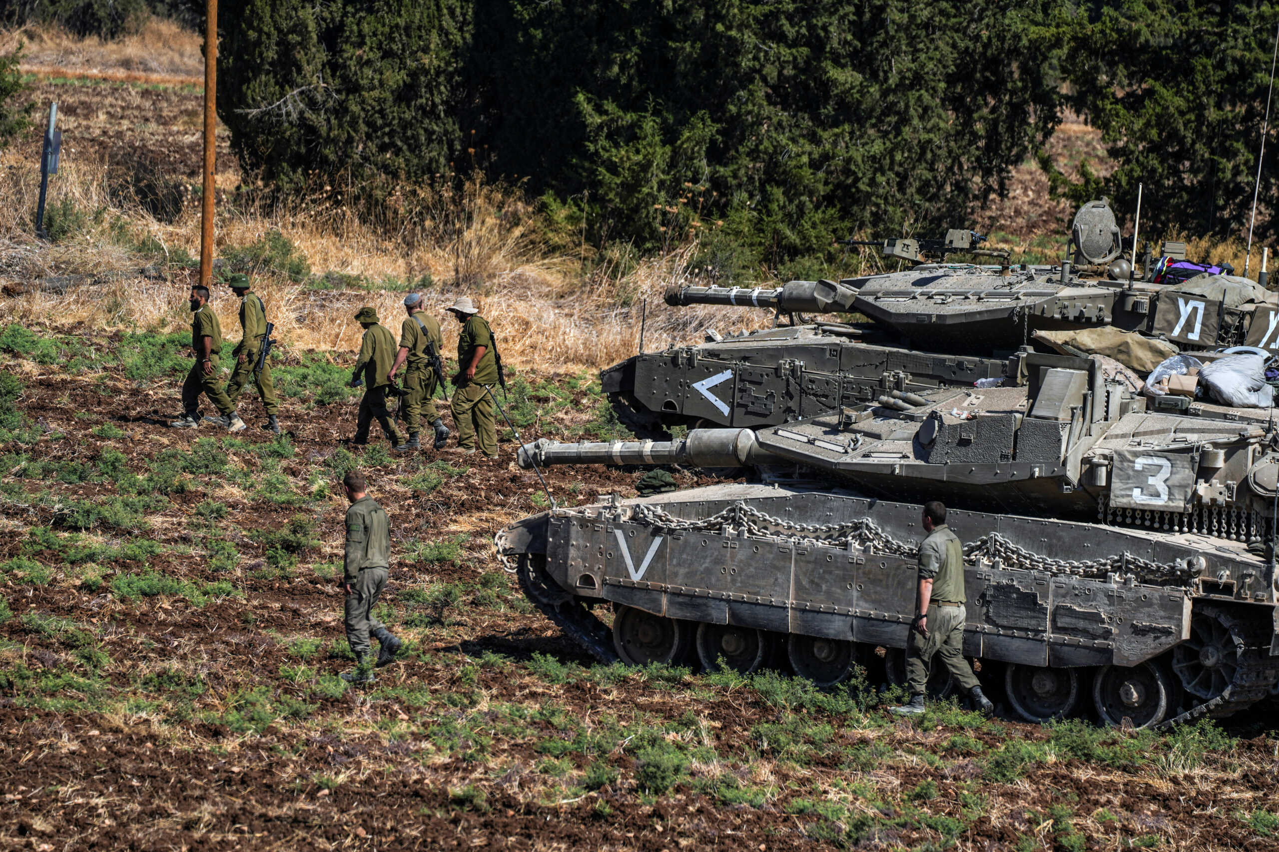 Israeli soldiers walk by tanks, amid cross-border hostilities between?Hezbollah?and Israel, in northern Israel, September 27, 2024. REUTERS