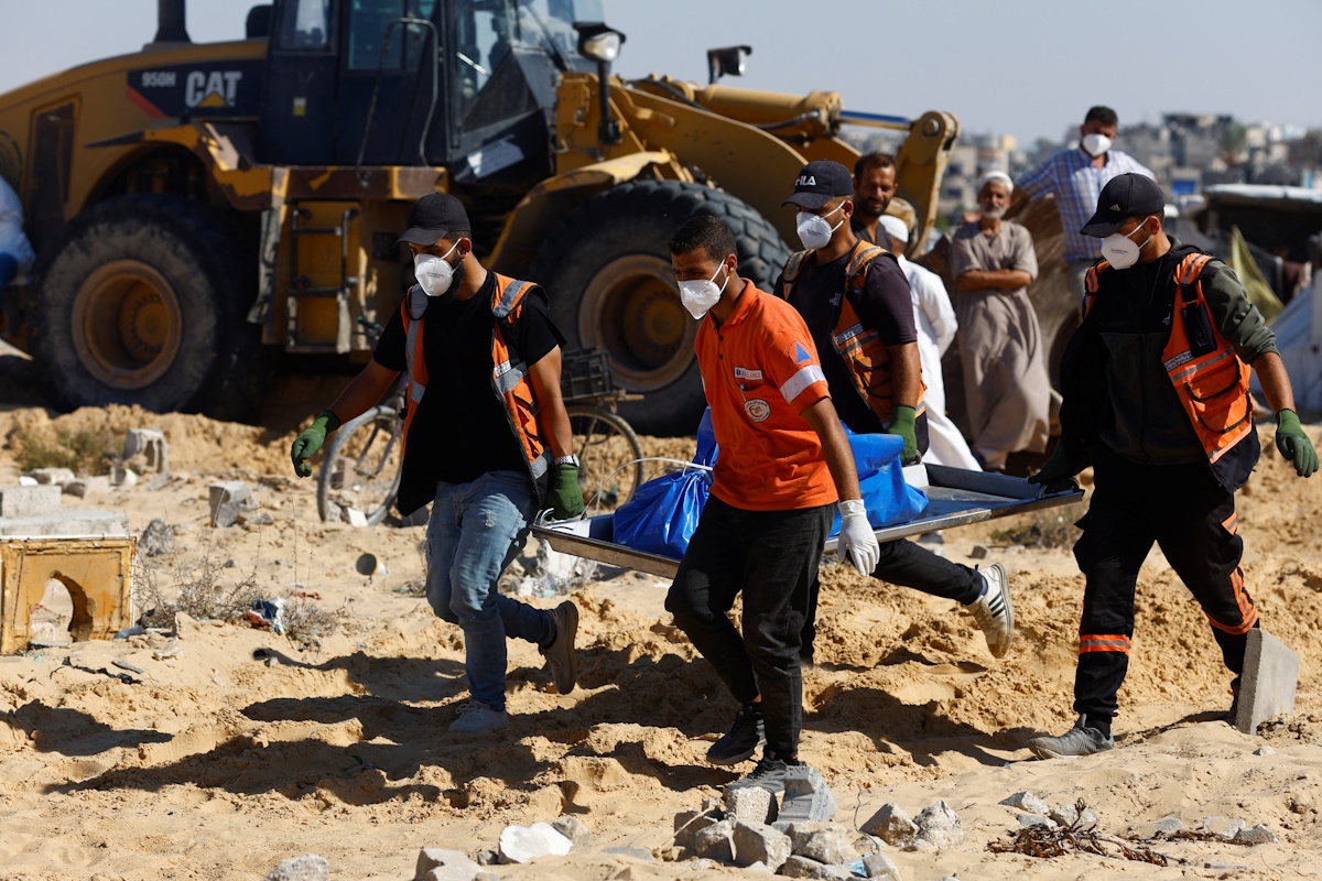 People bury in a mass grave unidentified bodies of Palestinians killed in Israel's military offensive, after they were handed over by Israel, amid the Israel-Hamas conflict, in Khan Younis in the southern Gaza Strip September 26, 2024. REUTERS