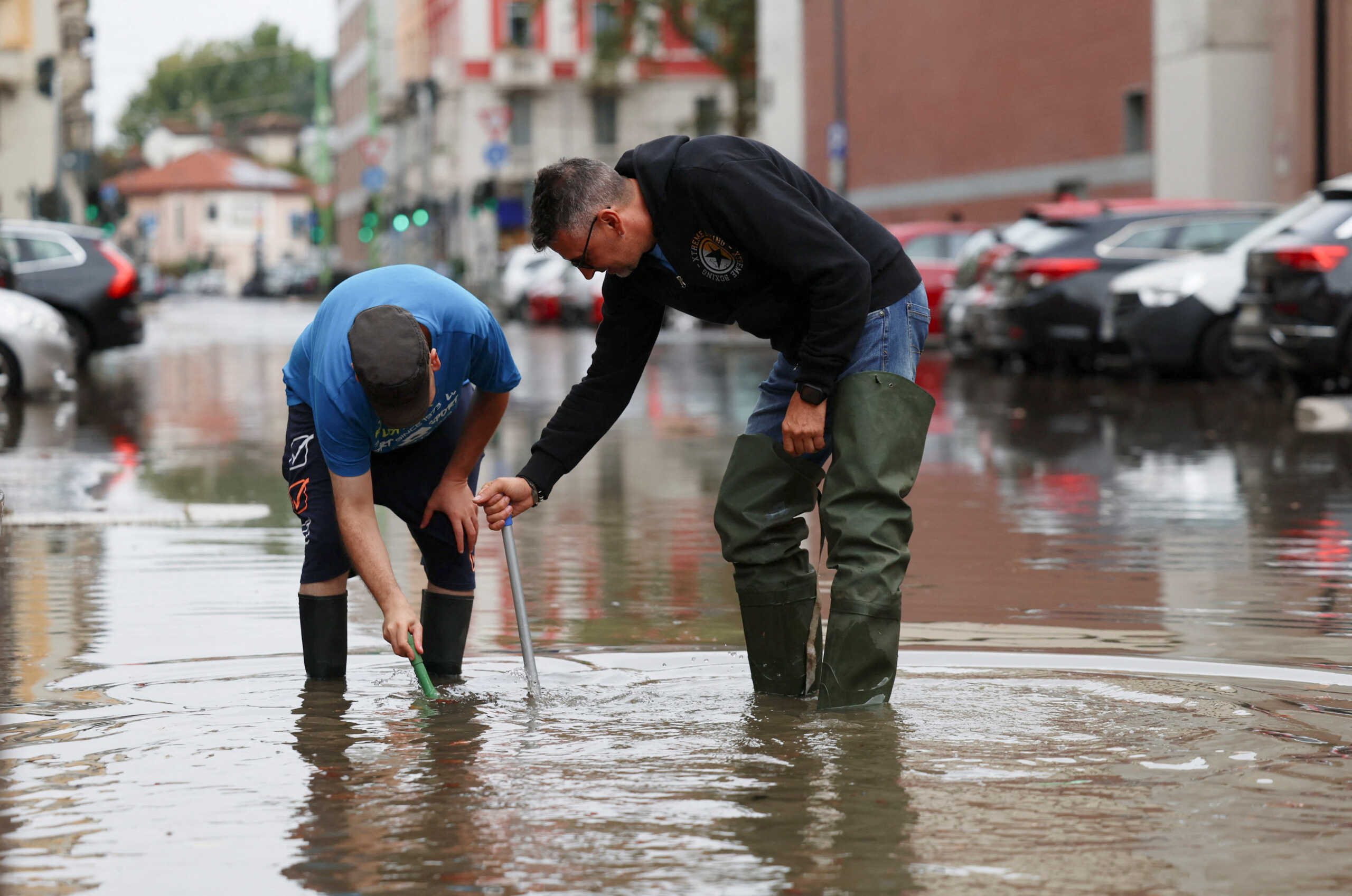 People work on a flooded road as heavy rains hit Milan, Italy, September 5, 2024. REUTERS