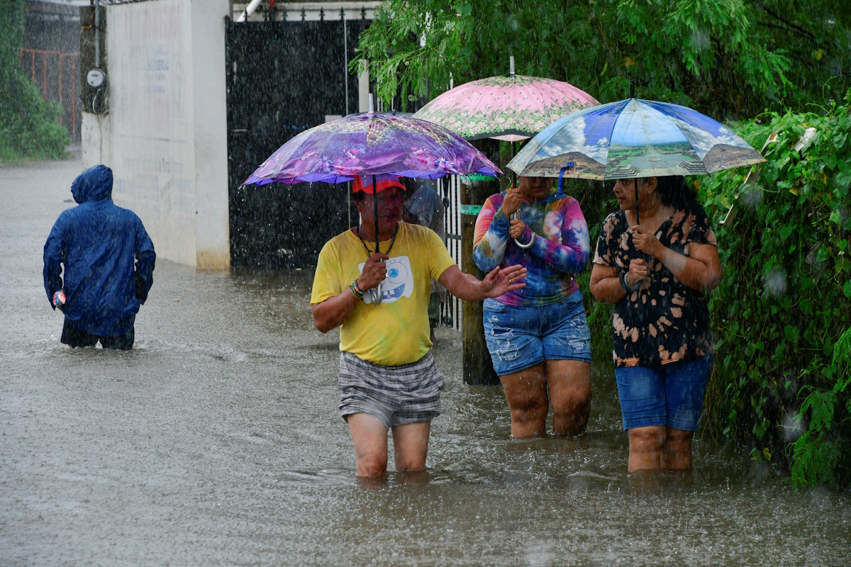 People walk on a flooded street as Tropical Storm John is on track to become a hurricane again, hurtling back towards communities across the Pacific coast, in Acapulco, Mexico September 25, 2024. REUTERS