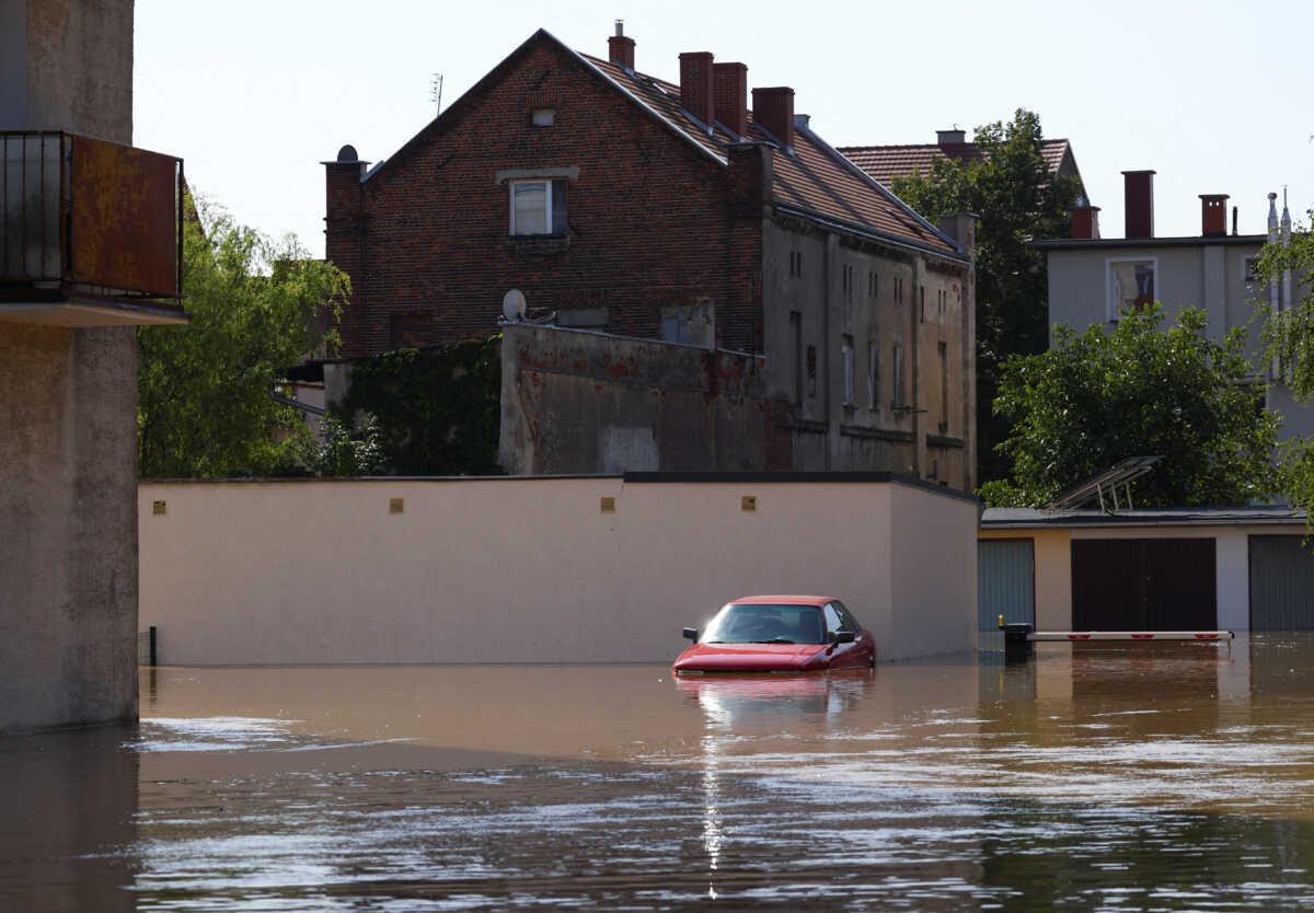 A car sits in the floodwater, in an area flooded by the Nysa Klodzka river, following heavy rainfalls, in Lewin Brzeski, Poland, September 17, 2024. REUTERS