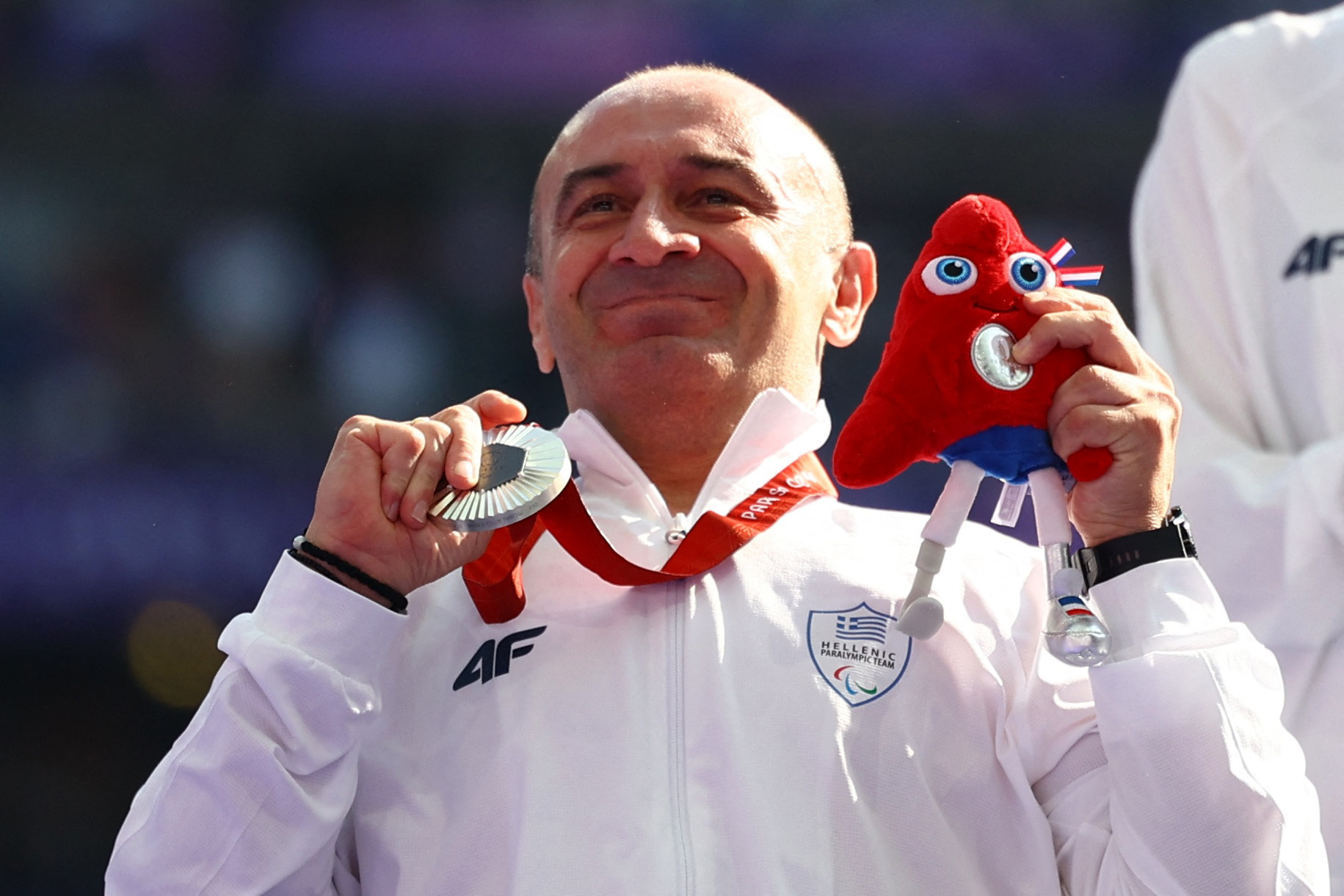 Paris 2024 Paralympics - Athletics - Men's Club Throw - F32 Medal Ceremony - Stade de France, Saint-Denis, France - September 1, 2024. Silver medallist Athanasios Konstantinidis of Greece celebrates on the podium. REUTERS