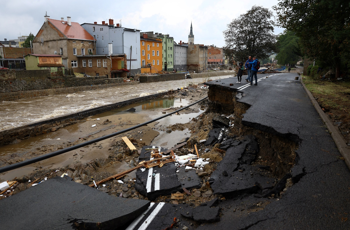 People stand on a destroyed road by the Biala Ladecka River during the aftermath of flooding in Ladek Zdroj, Poland September 16, 2024. REUTERS