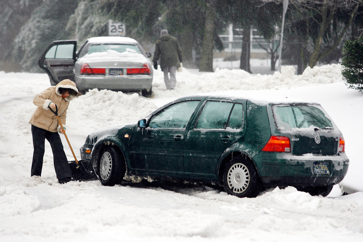Lubov Skurina clears out snow from uder her car after getting stuck trying to head back home in Pike Creek, Del., Wednesday, Feb. 14, 2007. People in Pike Creek began their Wednesday morning having to deal with cold, snow and ice. (AP Photo