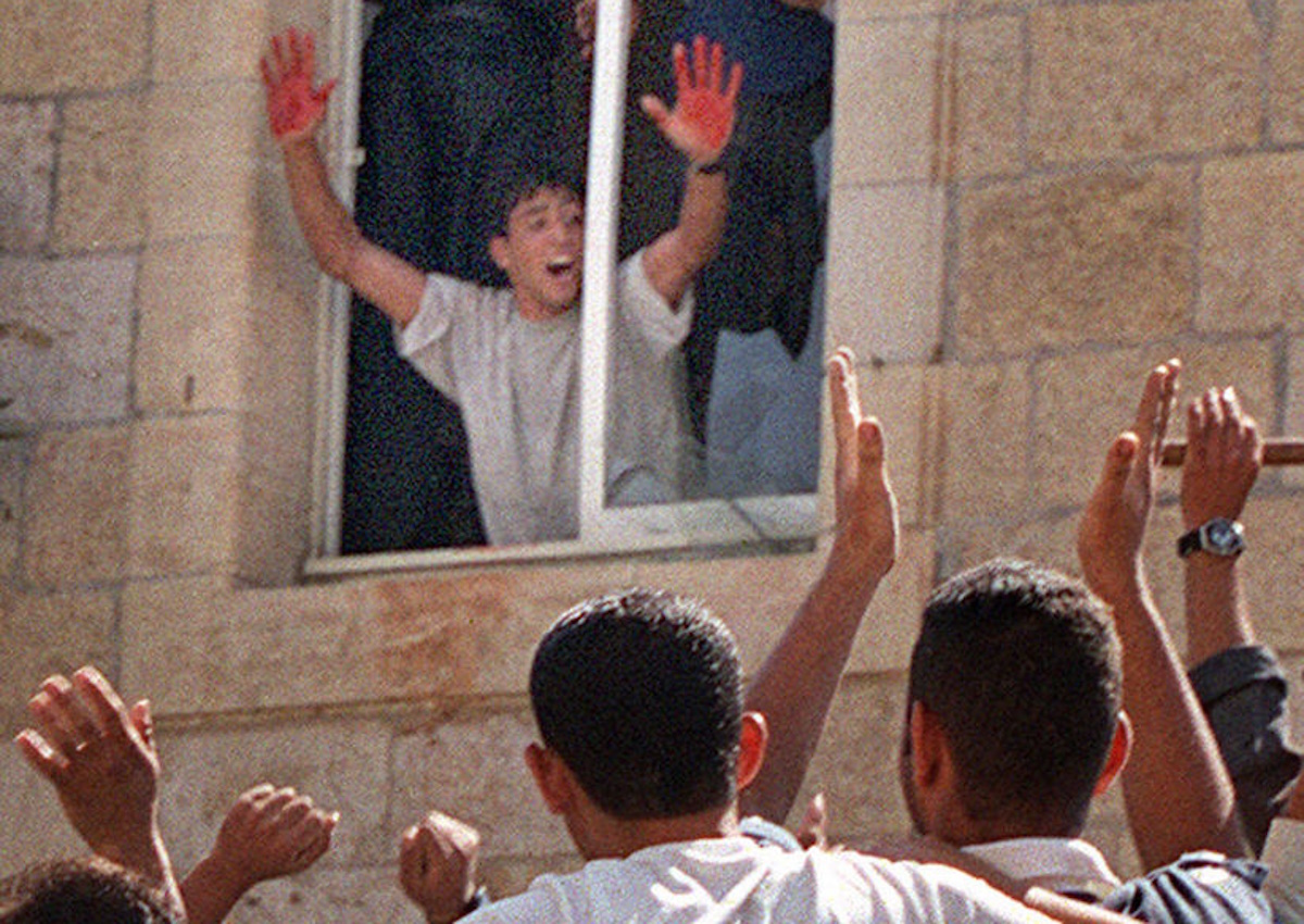 BEST QUALITY AVAILABLE
JER10 - 20001012 - RAMALLAH, WEST BANK, - : (Files) -- Picture dated 12 October 2000, shows a Palestinian youth proudly showing Israeli blood on his hands as he is cheered by fellow protesters at a Palestinian police station in the West bank town of Ramallah 12 October 2000, following the killing of two Israeli soldiers. The Israeli Prime Minister's office announced 25 June 2001 that Israeli forces have arrested the youth, identified as 20-year-old Aziz Salha who had confessed to chocking one of the soldiers. So far 15 Palestinians had already been arrested in connection with the killing.  (FILM)      EPA PHOTO         AFPI FILES
