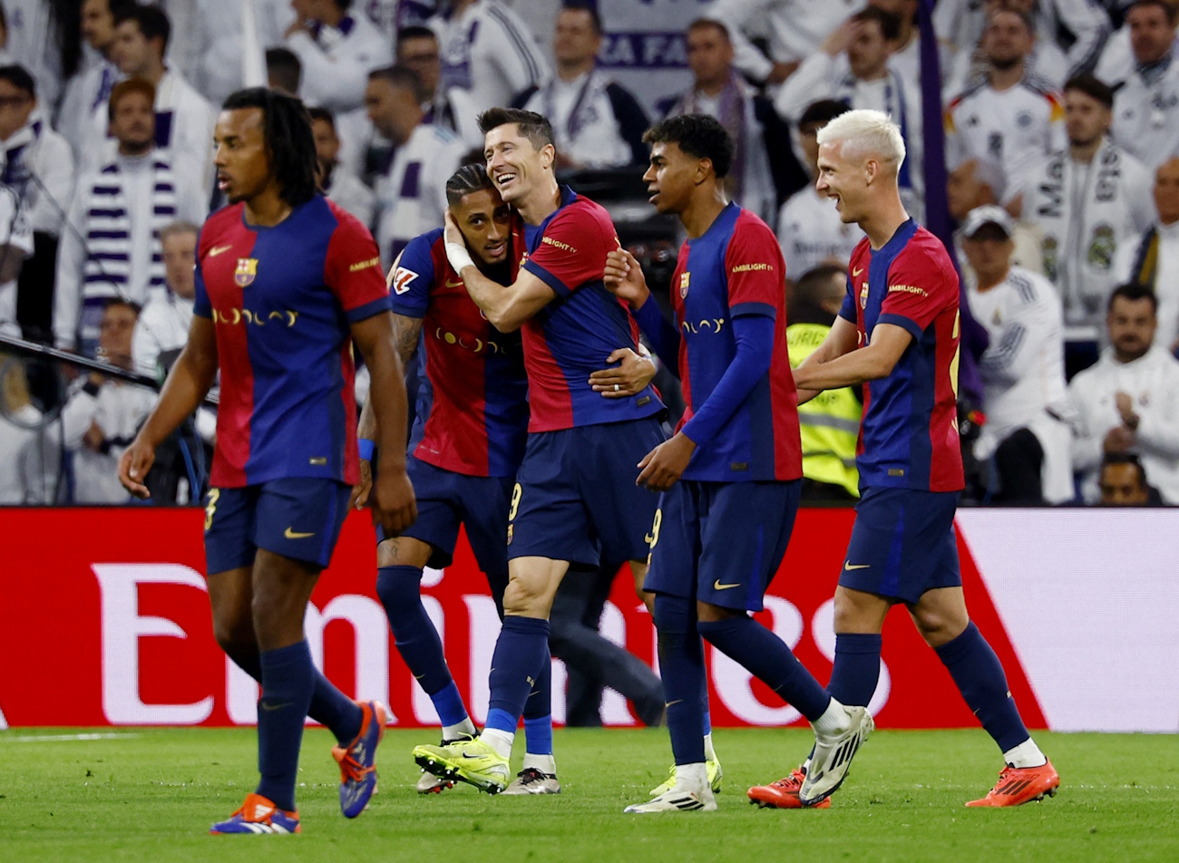 Soccer Football - LaLiga - Real Madrid v FC Barcelona - Santiago Bernabeu, Madrid, Spain - October 26, 2024 FC Barcelona's Raphinha celebrates scoring their fourth goal with Robert Lewandowski and teammates REUTERS