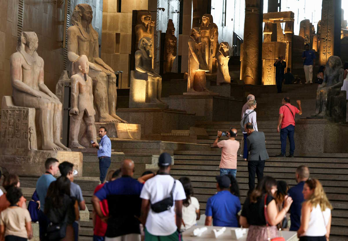 Tourists look at Pharaonic statues displayed at the Grand Staircase of the Grand Egyptian Museum during a partial trial in Giza, Egypt, October 15, 2024. REUTERS