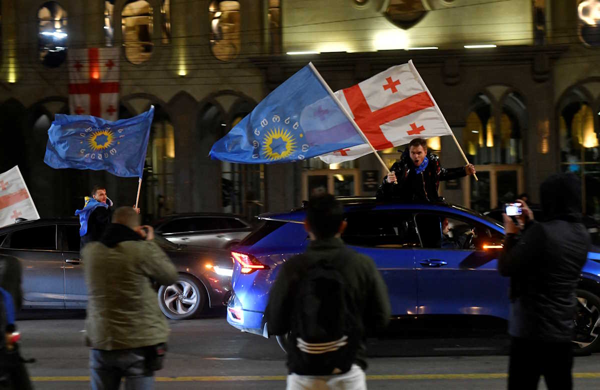 Supporters of the Georgian Dream party wave Georgian flags and the party's flags from cars after the announcement of exit poll results in parliamentary elections, in Tbilisi, Georgia October 26, 2024. REUTERS