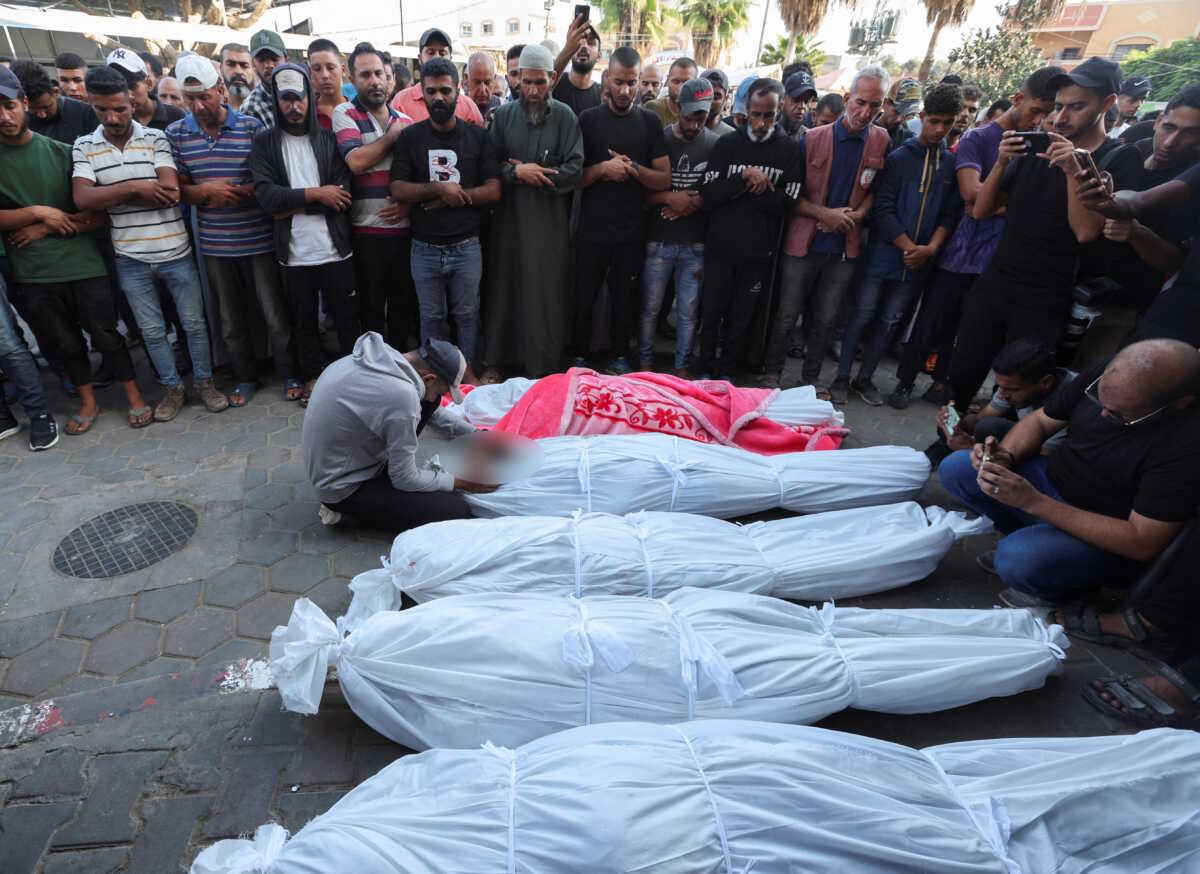 SENSITIVE MATERIAL. THIS IMAGE MAY OFFEND OR DISTURB Mourners pray next to the bodies of Palestinians, who were killed in an Israeli strike, amid the Israel-Hamas conflict, at Al-Aqsa Martyrs Hospital in Deir Al-Balah in the central Gaza Strip, October 6, 2024. REUTERS