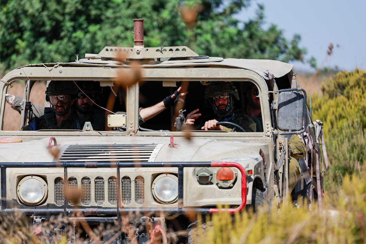Israeli soldiers sit in a military vehicle, amid hostilities between Hezbollah and Israel, in northern Israel, October 9, 2024. REUTERS