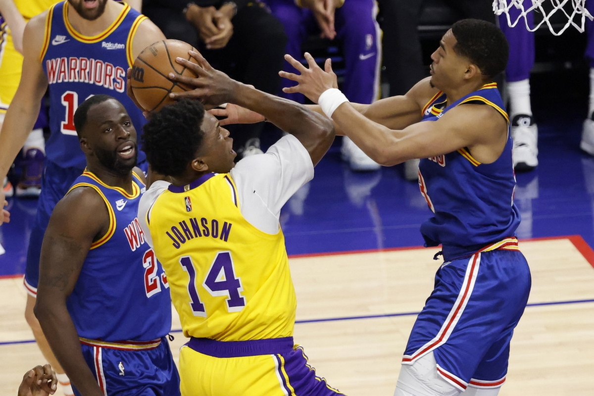 epa09877537 Los Angeles Lakers forward Stanley Johnson (C) goes to the basket while drawing a foul by Golden State Warriors guard Jordan Poole (R) during the first half of the NBA basketball game between the Los Angeles Lakers and the Golden State Warriors at the Chase Center in San Francisco, California, USA, 07 April 2022.  EPA
