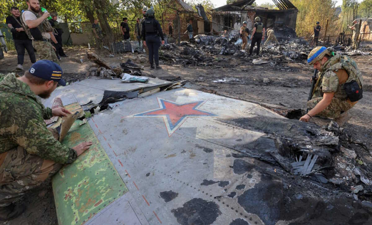 Ukrainian service members inspect parts of a Russian aerial vehicle, which local authorities assume to be a newest heavy unmanned aerial vehicle S-70 Okhotnik (Hunter) or variation of Sukhoi fighting jet, is seen in residential area of the town of Kostintynivka after it was shot down, amid Russia's attack on Ukraine, in Donetsk region, Ukraine October 5, 2024.  Radio Free Europe