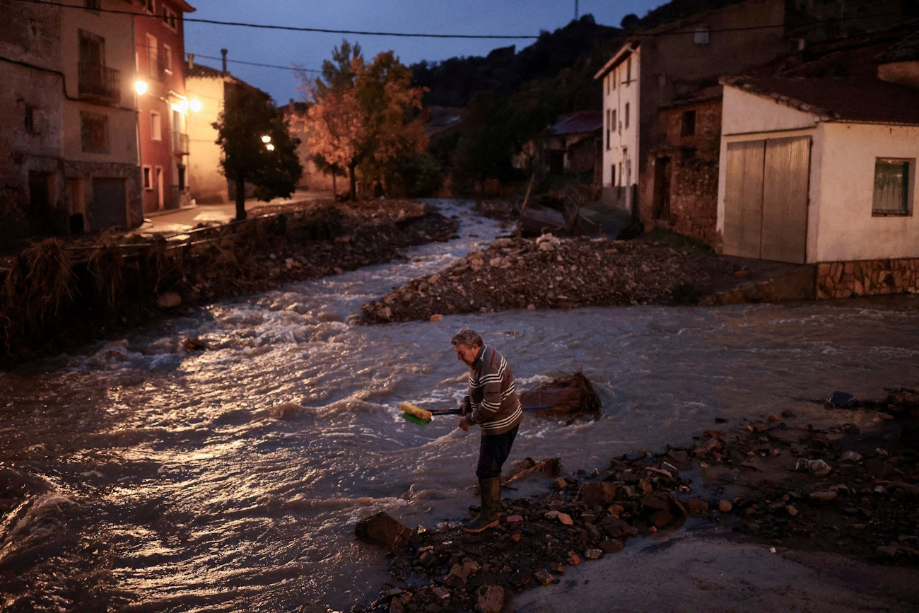 Miguel, 69, washes his sweeping brooms in the Dry River (Rio Seco) after cleaning his house, amid flooding caused by heavy rains, in La Hoz de la Vieja, Teruel province, Spain October 30, 2024. REUTERS