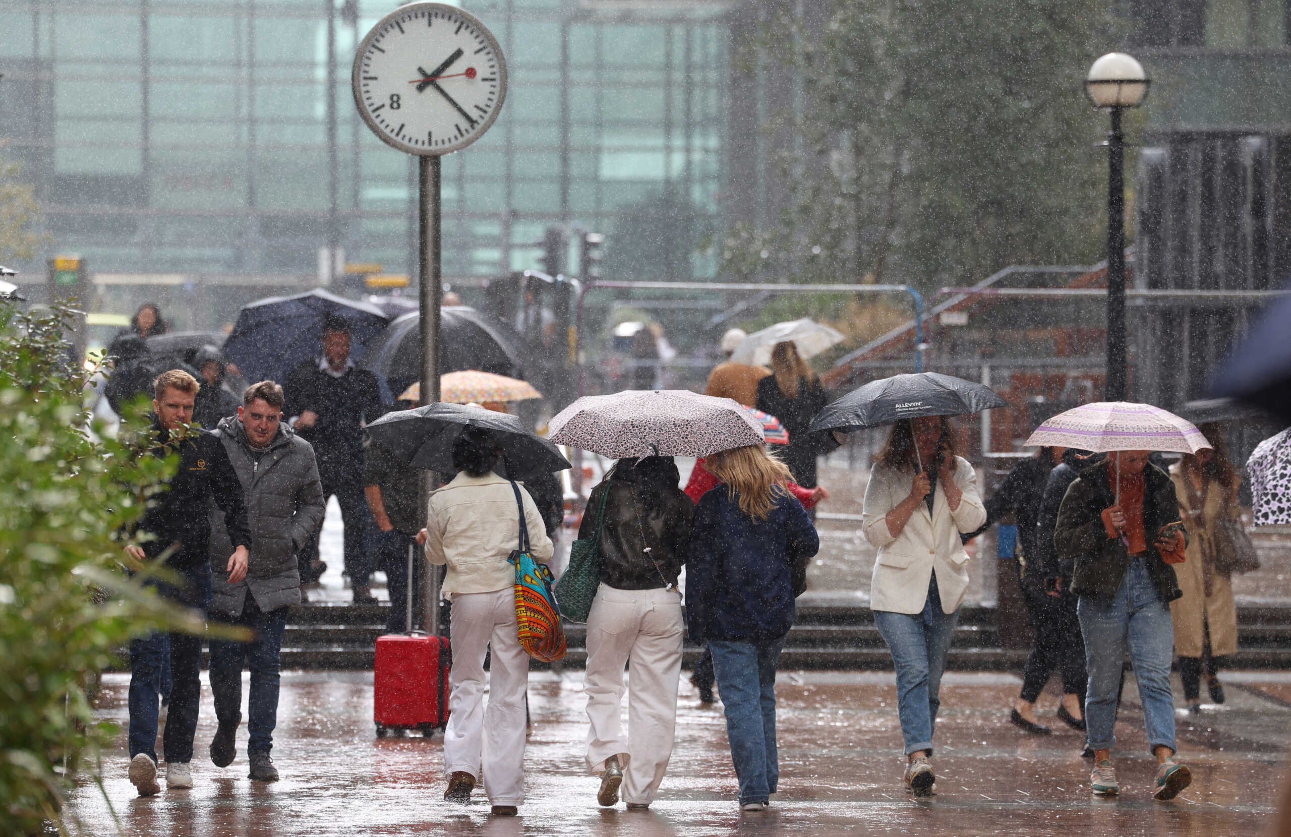 People walk during heavy rain, as flooding continues in areas of the country, in the Canary Wharf financial district of London, Britain, September 26, 2024. REUTERS