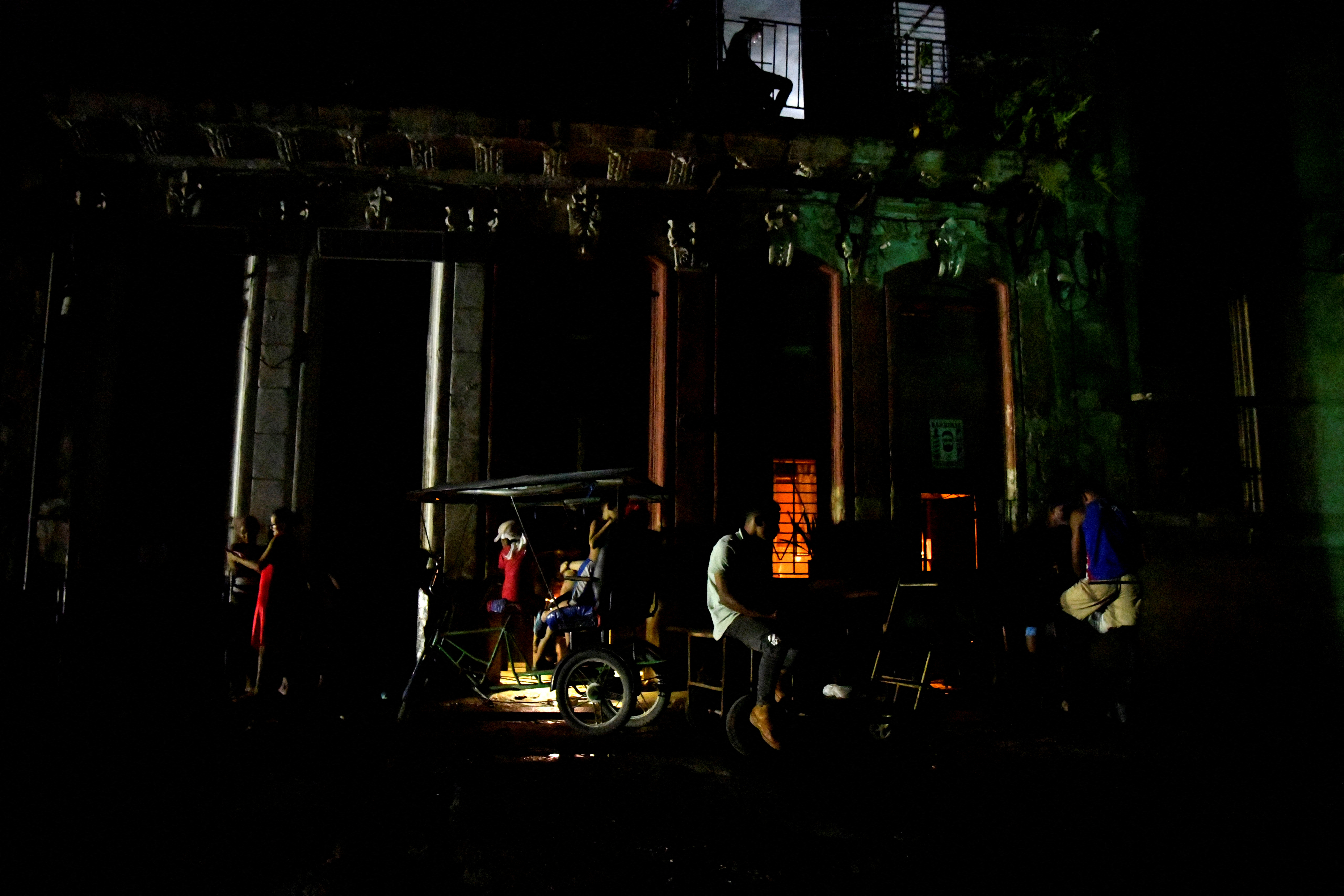 People gather in the street at night as Cuba is hit by an island-wide blackout, in Havana, Cuba, October 18, 2024. REUTERS