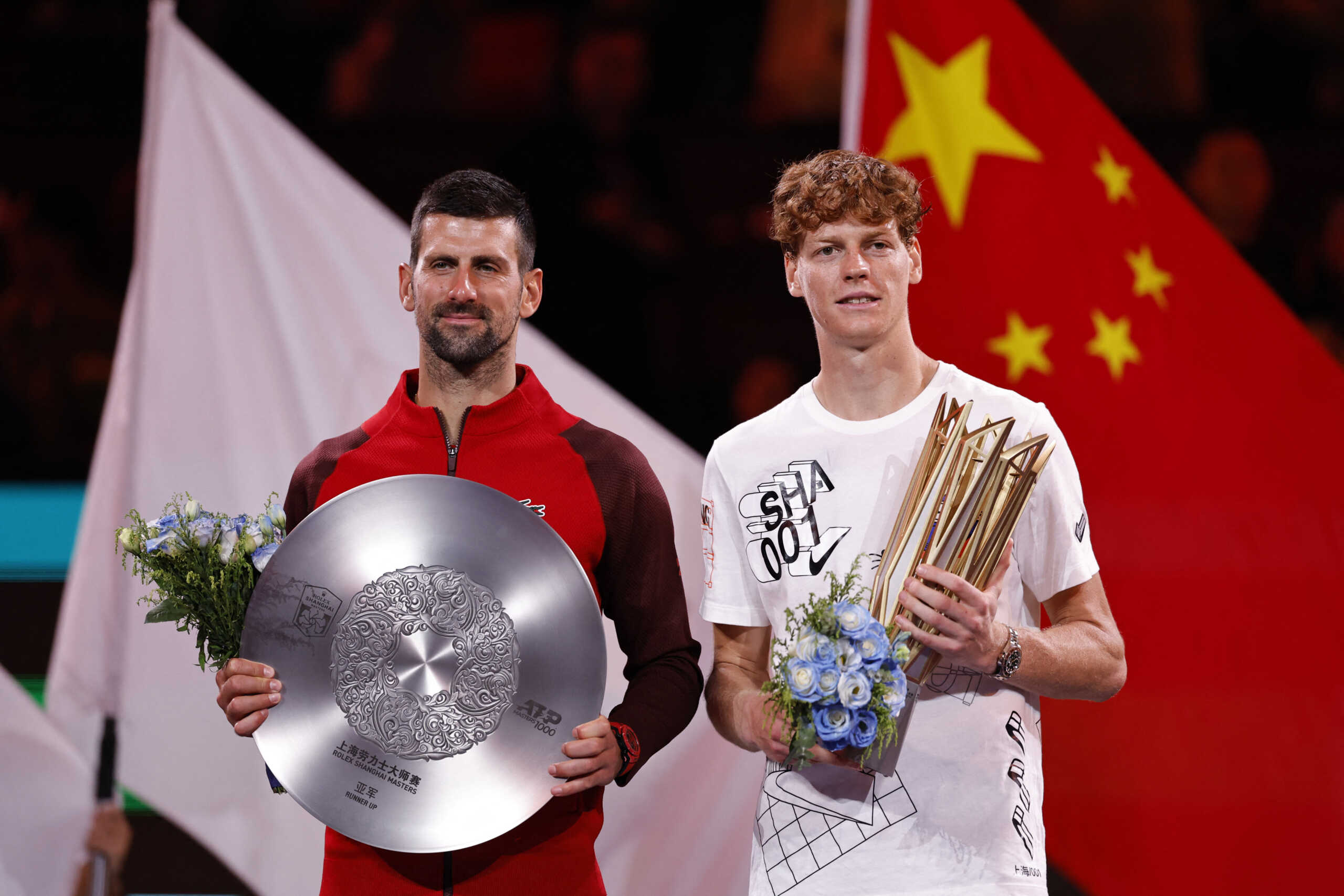 Tennis - Shanghai Masters - Qizhong Forest Sports City Arena, Shanghai, China - October 13, 2024 Italy's Jannik Sinner celebrates with the trophy after winning his final match as Serbia's Novak Djokovic poses with the runners up trophy REUTERS