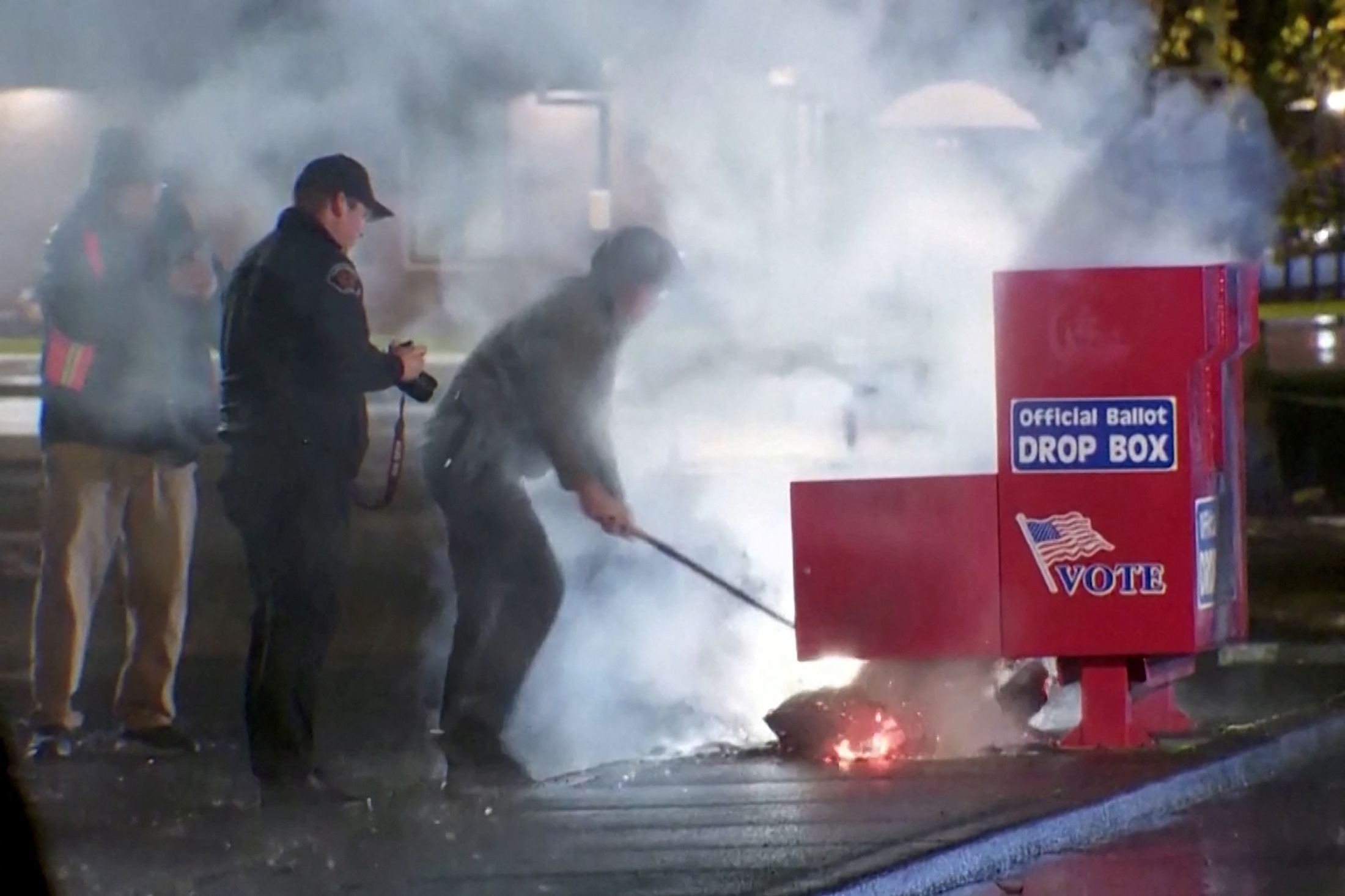 First responders pull out the burning contents of a ballot box, used to collect early votes ahead of the Nov. 5 U.S. election, after it was set on fire in a suspected arson in Vancouver, Washington, U.S. October 28, 2024 in a still image from video.  Evan Bell