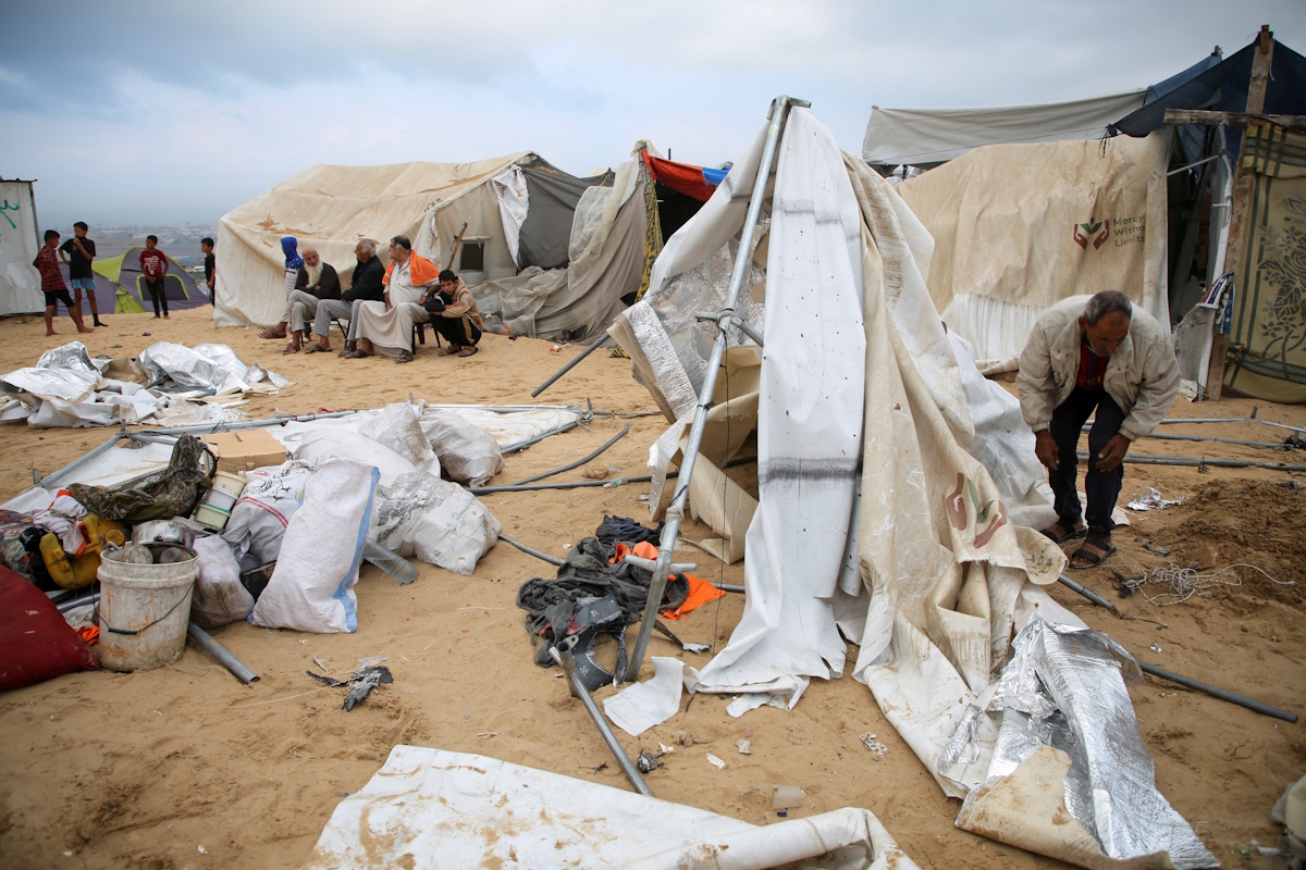Palestinians inspect the damage at the site of an Israeli strike on a tent camp sheltering displaced people, amid the ongoing Israel-Hamas conflict, in Al-Mawasi area in Khan Younis, in the southern Gaza Strip, October 15, 2024. REUTERS