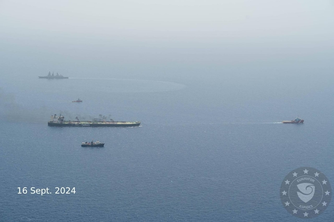 Tugboats, escorted by military vessels, tow the damaged Greek-flagged oil tanker MV Sounion, which has been on fire since August 23, after an attack by Houthi militants, on the Red Sea, September 16, 2024 in this handout image. EUNAVFOR ASPIDES