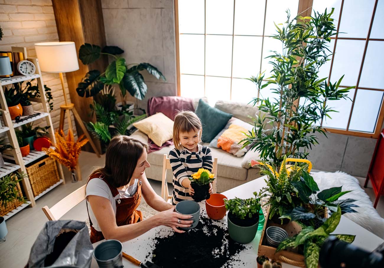 Mother and daughter planting flowers at home