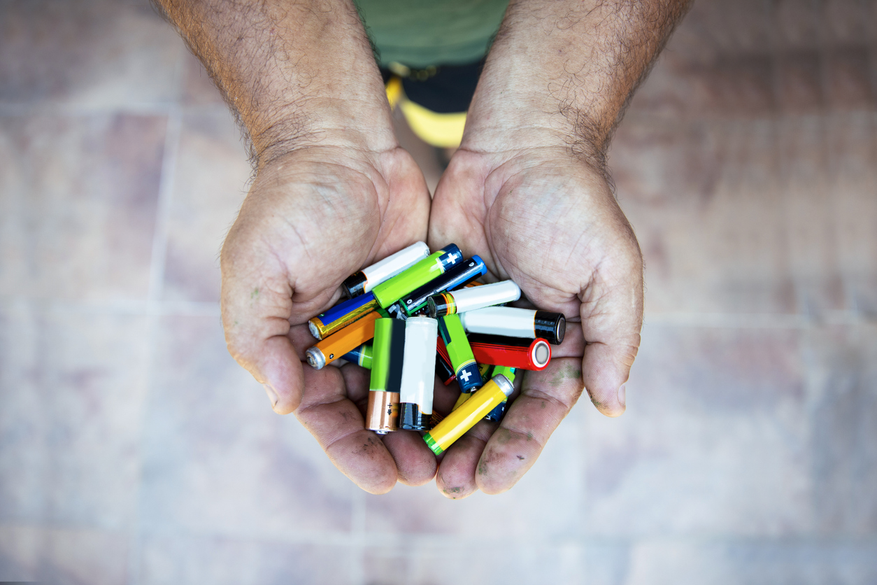 Man hands with variety of Batteries. Close up. Copy space