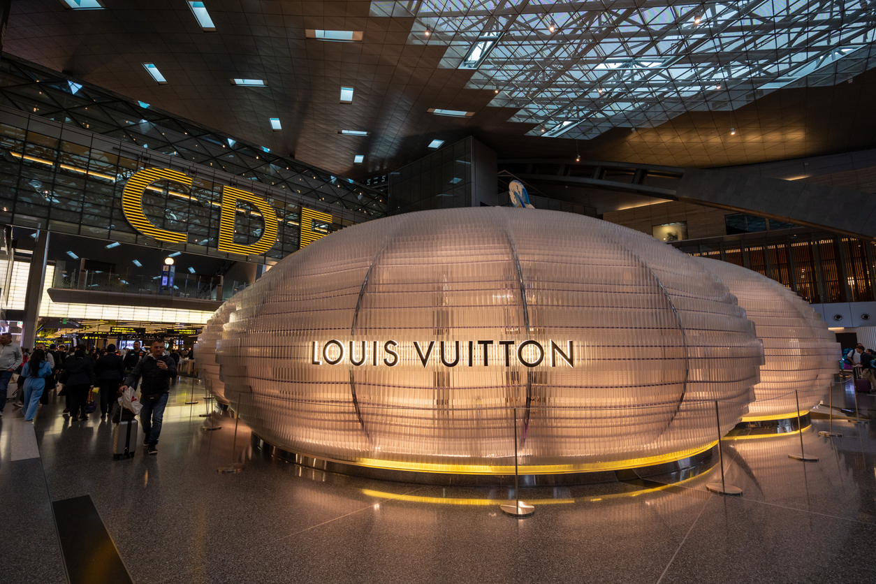 Doha, Qatar - February 20, 2024 : People walk past a Louis Vuitton store in Hamad International Airport in Doha, Qatar.