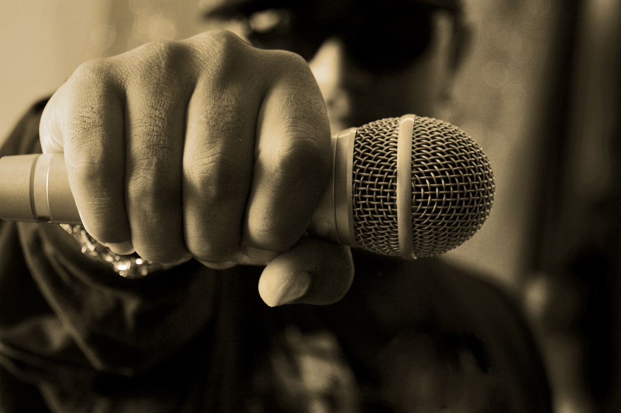 masculine hand with microphone held in it