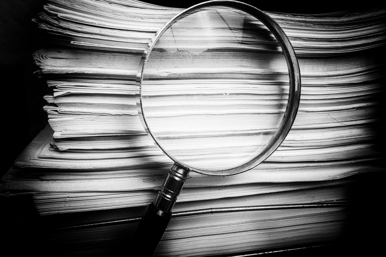 Handheld Magnify glass inspects paper documents