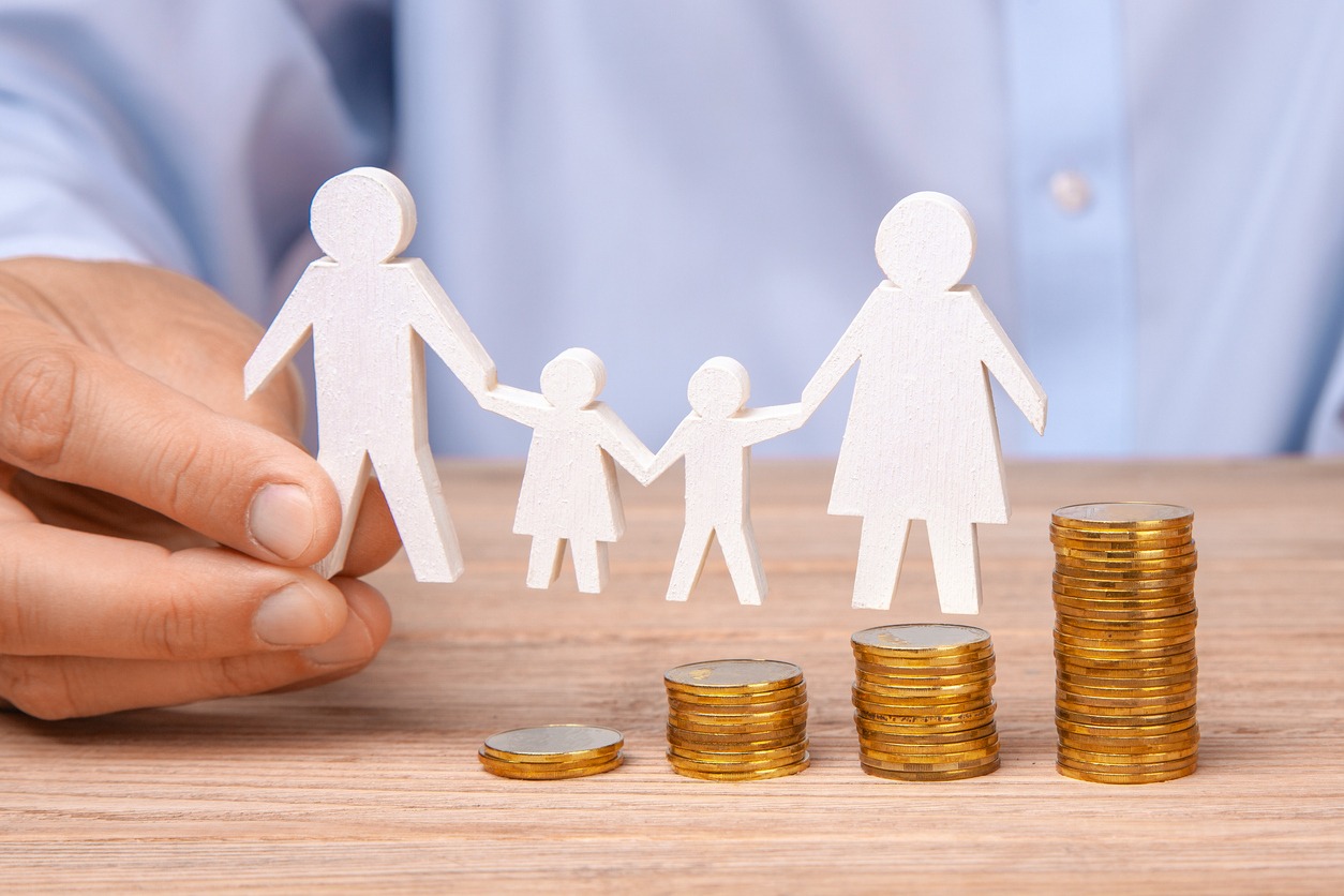 Budget of the family. Coins pile and the symbol of the family with the pope, mother, daughter and son