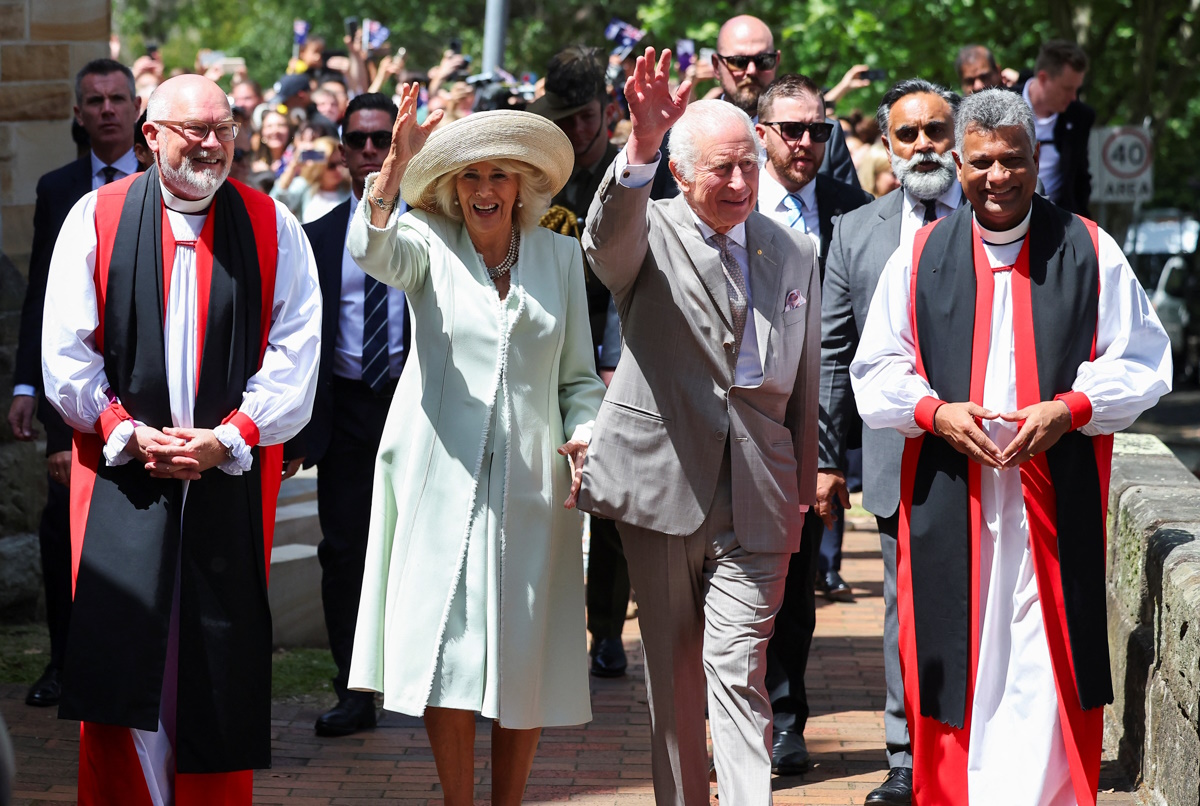 Britain's King Charles and Queen Camilla wave as they walk accompanied by Anglican Archbishop of Sydney Reverend Kanishka Raffel and Bishop Chris Edwards, during a visit to St. Thomas's Anglican Church, in Sydney, Australia, October 20, 2024. REUTERS