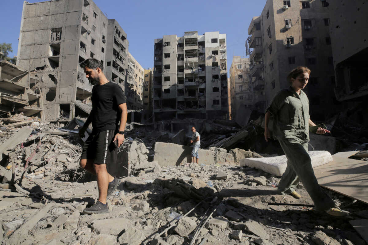 FILE PHOTO: People walk on the rubble at the site of the Israeli airstrike that killed Lebanon's Hezbollah leader Sayyed Hassan Nasrallah on Friday, in Beirut's southern suburbs, Lebanon, September 29, 2024.   REUTERS