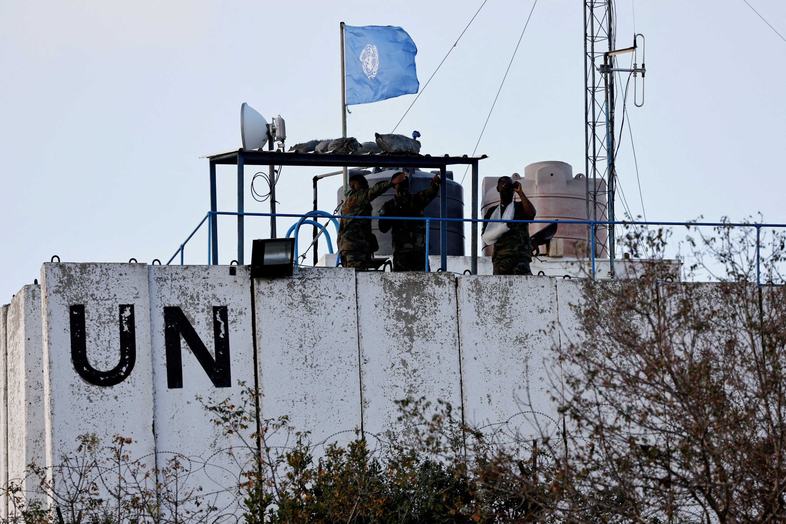FILE PHOTO: Members of the United Nations peacekeepers (UNIFIL) look at the Lebanese-Israeli border, as they stand on the roof of a watch tower ‏in the town of Marwahin, in southern Lebanon, October 12, 2023. REUTERS