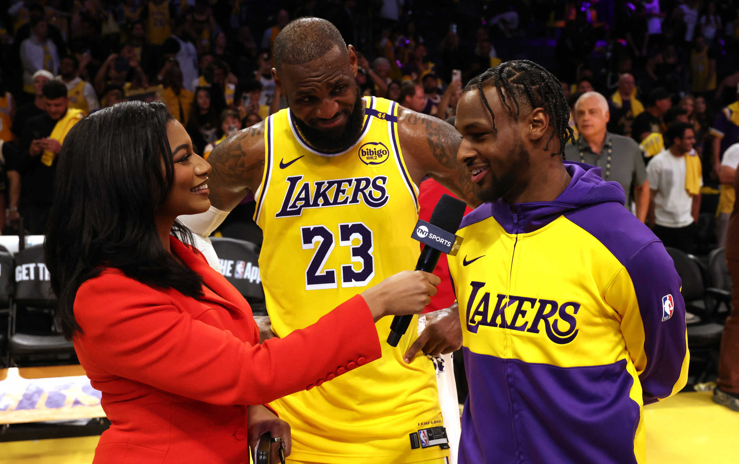 Oct 22, 2024; Los Angeles, California, USA; NBA on TNT sideline reporter Taylor Rooks interviews Los Angeles Lakers forward LeBron James (23) and guard Bronny James (9) after they defeated the Minnesota Timberwolves at Crypto.com Arena. Mandatory Credit: Jason Parkhurst-Imagn Images