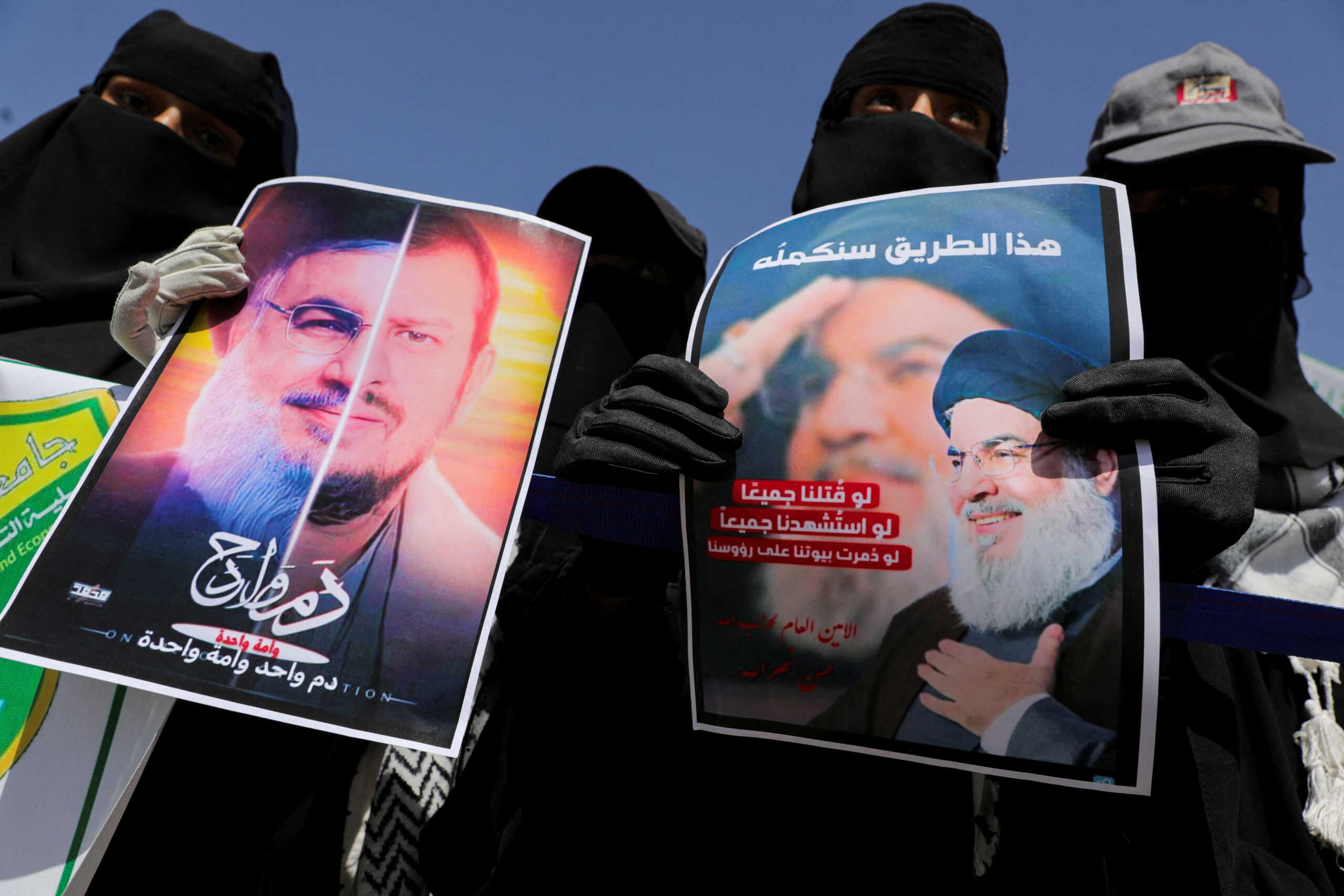 A student holds a poster with the faces of Hassan Nasrallah, the assassinated chief of Lebanon's Hezbollah, and Houthi leader Abdul-Malik al-Houthi, during a rally in Sanaa, Yemen October 2, 2024. REUTERS