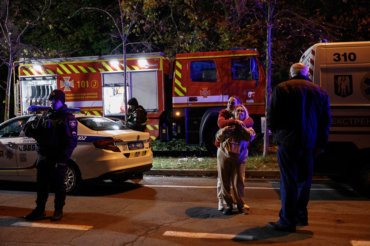 Residents look on, while rescue workers attend to the scene, outside an apartment building that was damaged during a Russian drone strike, amid Russia's attack on Ukraine, in Kyiv, Ukraine October 25, 2024. REUTERS