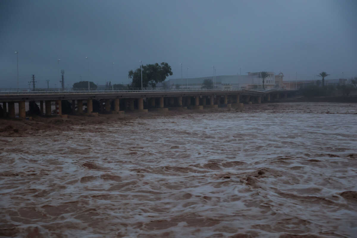 River water churns, with a partially collapsed bridge seen in the background, after torrential rains caused flooding in the town of Carlet, Valencia region, Spain, October 30, 2024. REUTERS