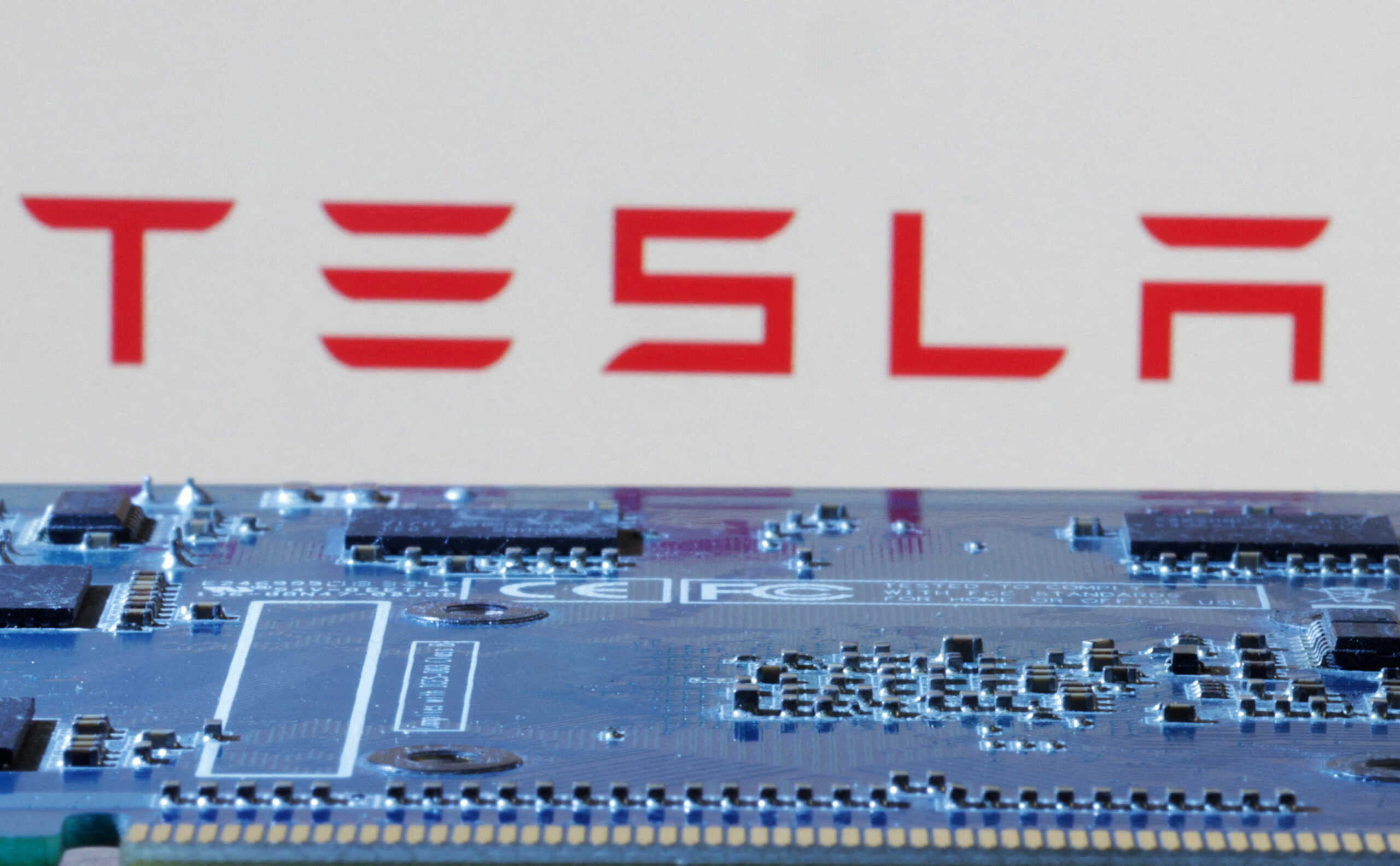 FILE PHOTO: Tesla logo is seen near computer motherboard in this illustration taken January 8, 2024. REUTERS