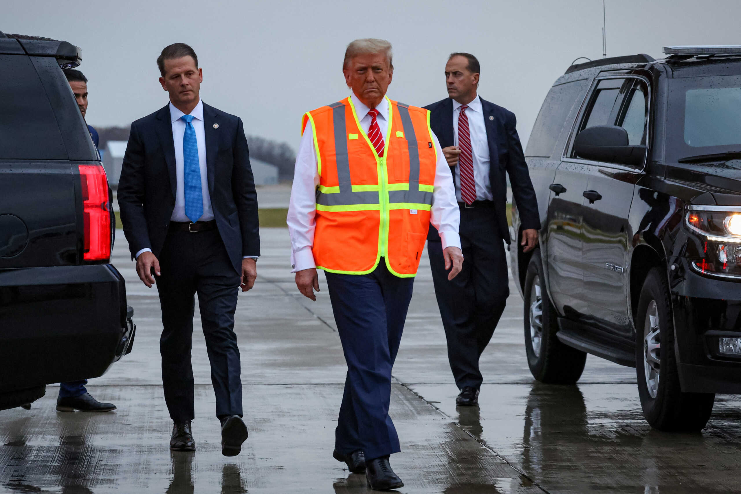 Republican presidential nominee and former U.S. President Donald Trump wears a high-vis vest, as he walks on tarmac at Green Bay Austin Straubel International Airport in Green Bay, Wisconsin, U.S., October 30, 2024. REUTERS