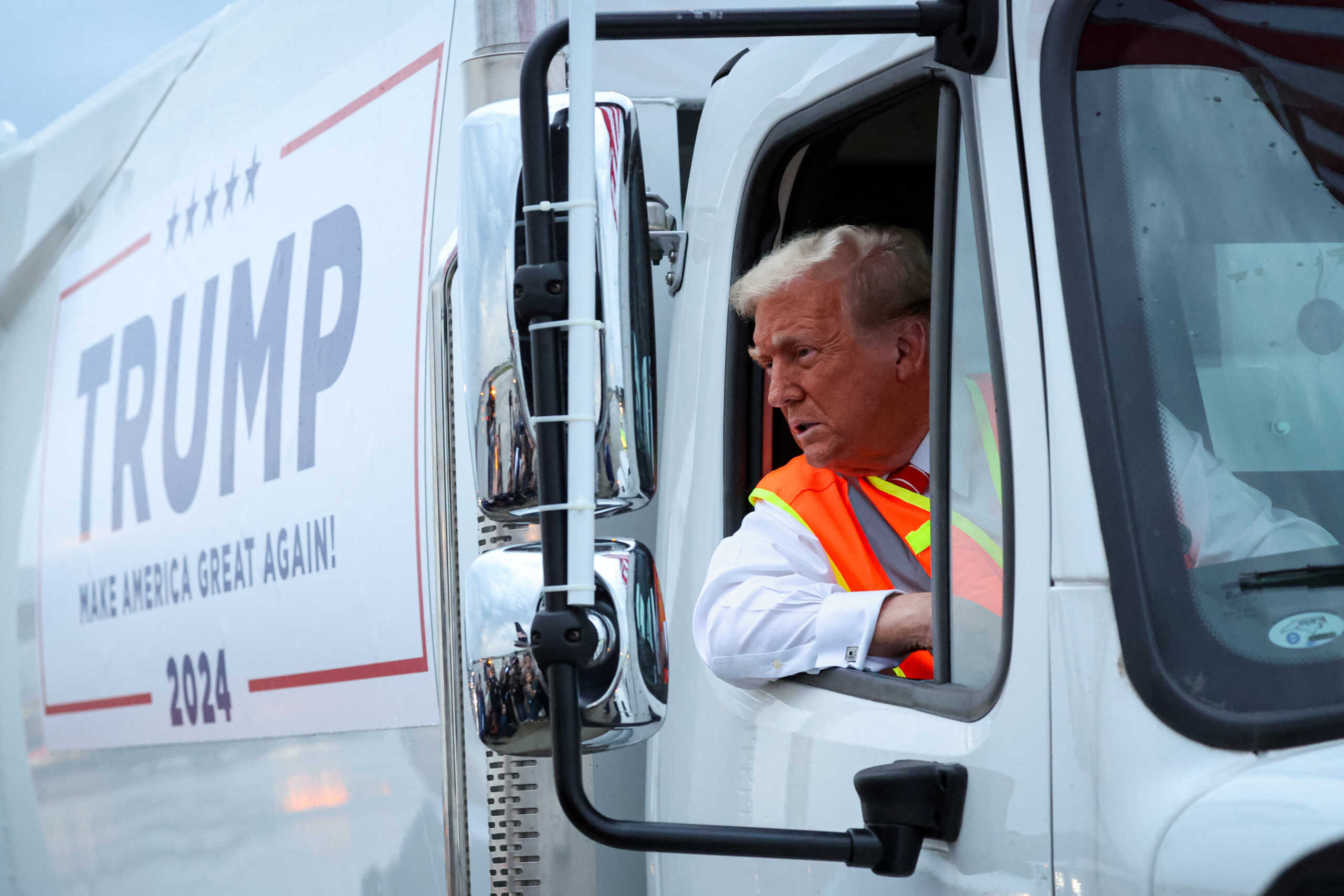 Republican presidential nominee and former U.S. President Donald Trump sits inside garbage truck as he wears a high-vis vest, on tarmac at Green Bay Austin Straubel International Airport in Green Bay, Wisconsin, U.S., October 30, 2024. REUTERS