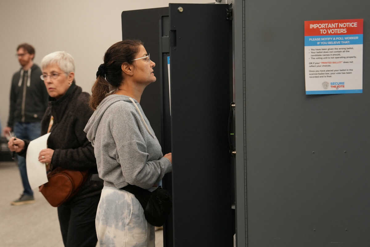 Voters take part in early election voting at a polling station in Marietta, Georgia, U.S. October 15, 2024.  REUTERS
