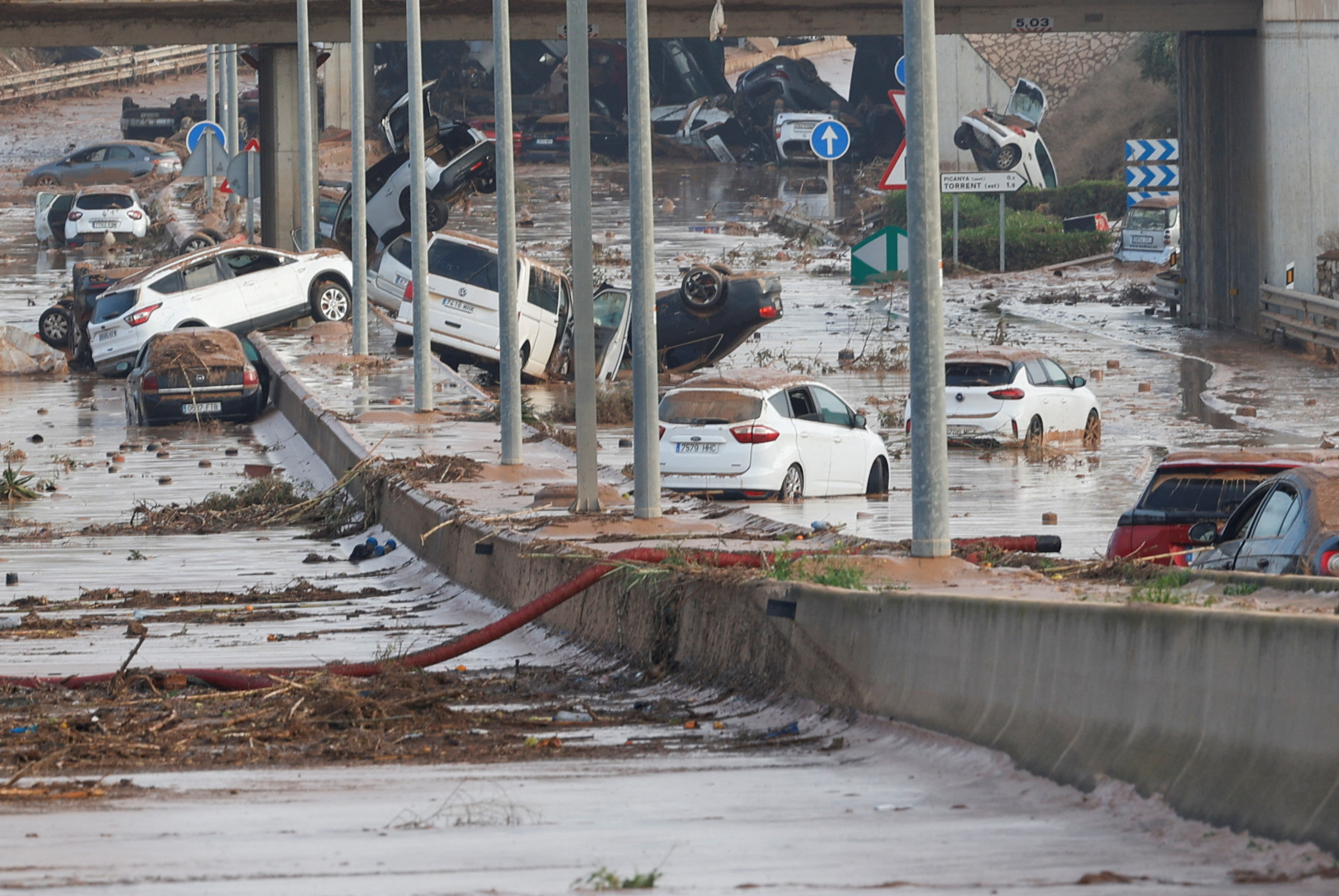 Damaged cars are seen along a road affected by torrential rains that caused flooding, on the outskirts of Valencia, Spain, October 31, 2024. REUTERS