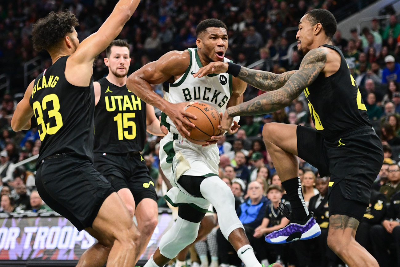 Nov 7, 2024; Milwaukee, Wisconsin, USA; Milwaukee Bucks forward Giannis Antetokounmpo (34) drives for the basket against Utah Jazz guard Johnny Juzang (33), forward Drew Eubanks (15) and center John Collins (20) in the fourth quarter at Fiserv Forum. Mandatory Credit: Benny Sieu-Imagn Images