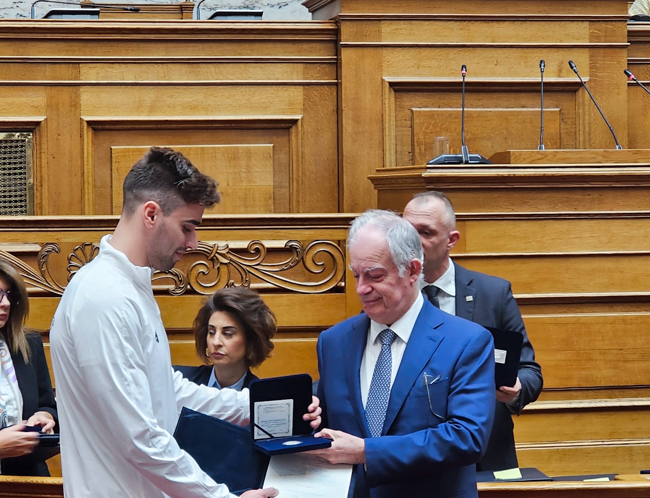 Η Βουλή των Ελλήνων τίμησε Ολυμπιονίκες και Παραολυμπιονίκες
Η Βουλή των Ελλήνων τίμησε τους Ολυμπιονίκες και τους Παραολυμπιακών του
Παρισιού σε μία ειδική τελετή στην αίθουσα της Ολομέλειας και τους απένειμε το
Μετάλλιο της Βουλής των Ελλήνων.
Η εκδήλωση έγινε στο πλαίσιο της Διάσκεψης με θέμα «Προωθώντας την ασφάλεια,
την ακεραιότητα, την ισότητα και τη συμπερίληψη στον αθλητισμό» που
διοργάνωσαν η Βουλή των Ελλήνων και η Κοινοβουλευτική Συνέλευση του
Συμβουλίου της Ευρώπης με τον Πρόεδρος της Βουλής κ. Κωνσταντίνο Τασούλα να
καλωσορίζει τους αθλητές και τις αθλήτριες που πήραν από την 1 η έως την 8 η θέση
στους Ολυμπιακούς και τους Παραολυμπιακούς Αγώνες «Παρίσι 2024».
Στο χαιρετισμό του ο Πρόεδρος της Ελληνικής Ολυμπιακής Επιτροπής Σπύρος
Καπράλος επισήμανε την μείωση των αθλητικών εγκαταστάσεων με πολλά
αθλήματα να μην έχουν στέγη και επανέλαβε την πρόταση της ΕΟΕ οι αθλητές που
διακρίθηκαν από 1η έως 8η θέση στους Ολυμπιακούς Αγώνες να λαμβάνουν θέσεις
στον ευρύτερο Δημόσιο Τομέα.
Μεταξύ άλλων ο κ. Καπράλος είπε