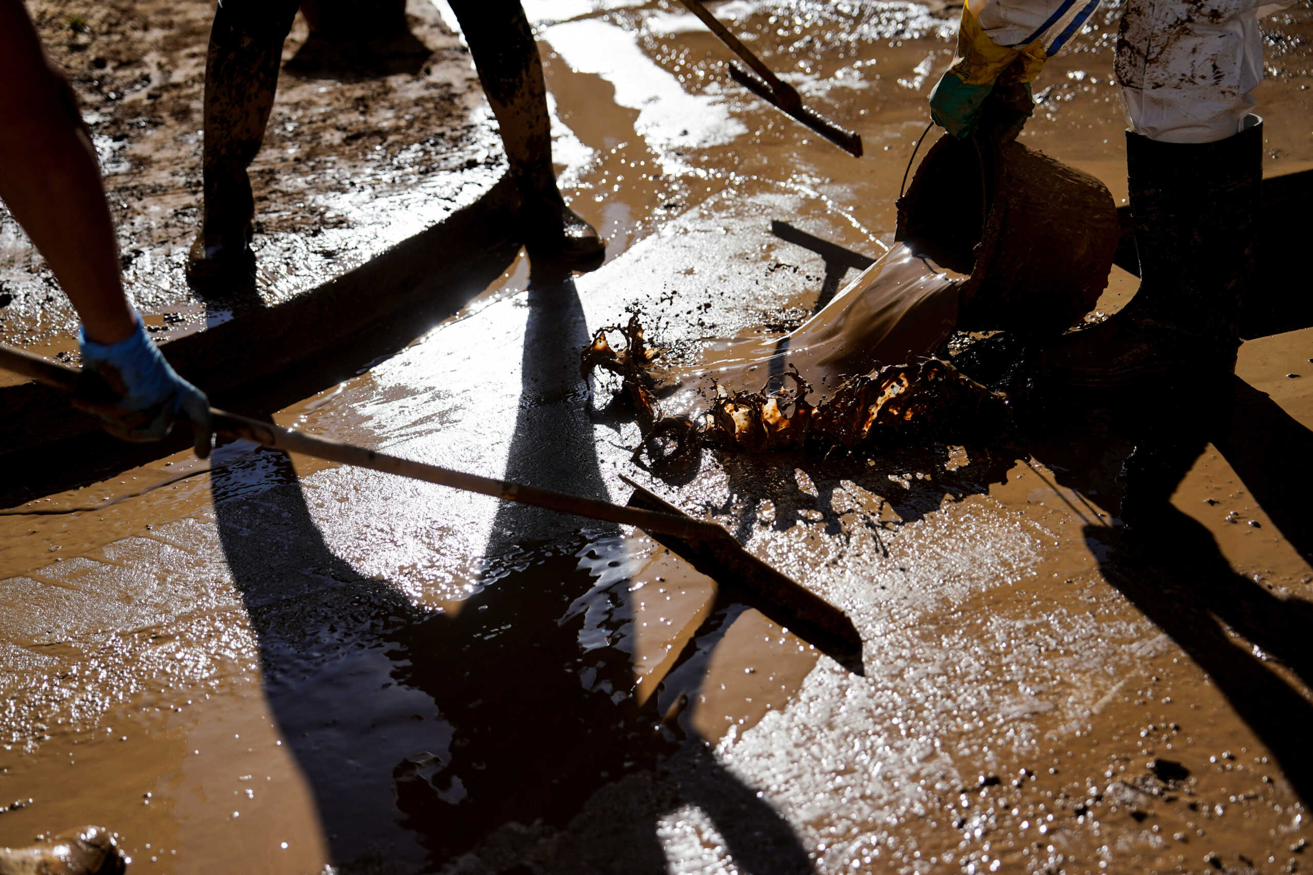 People clean mud from a street, in the aftermath of the flooding caused by heavy rains in Catarroja, near Valencia, Spain November 10, 2024. REUTERS