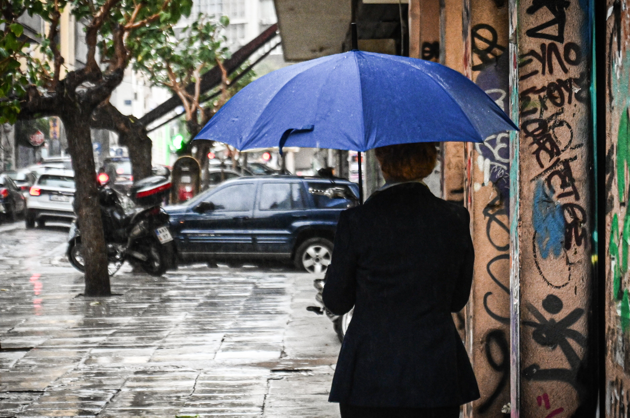 Κόσμος περπατά κρατώντας ομπρέλες, σε διάβαση στο κέντρο της Αθήνας, κατά την διάρκεια βροχόπτωσης, Παρασκευή 15 Νοεμβρίου 2024. (ΚΩΣΤΑΣ ΤΖΟΥΜΑΣ