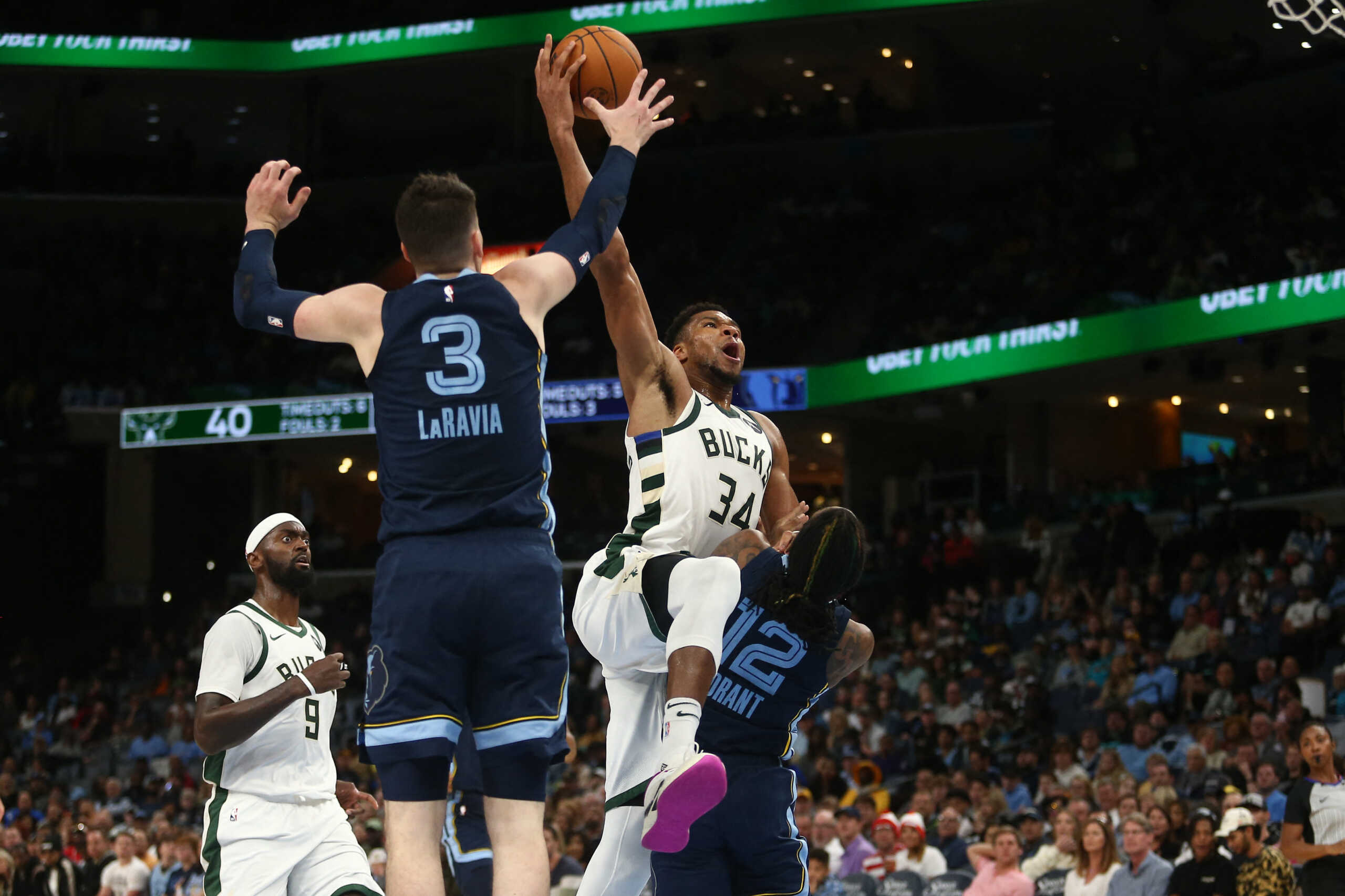 Oct 31, 2024; Memphis, Tennessee, USA; Milwaukee Bucks forward Giannis Antetokounmpo (34) drives to the basket as Memphis Grizzlies forward Jake LaRavia (3) and guard Ja Morant (12) defends during the first half at FedExForum. Mandatory Credit: Petre Thomas-Imagn Images