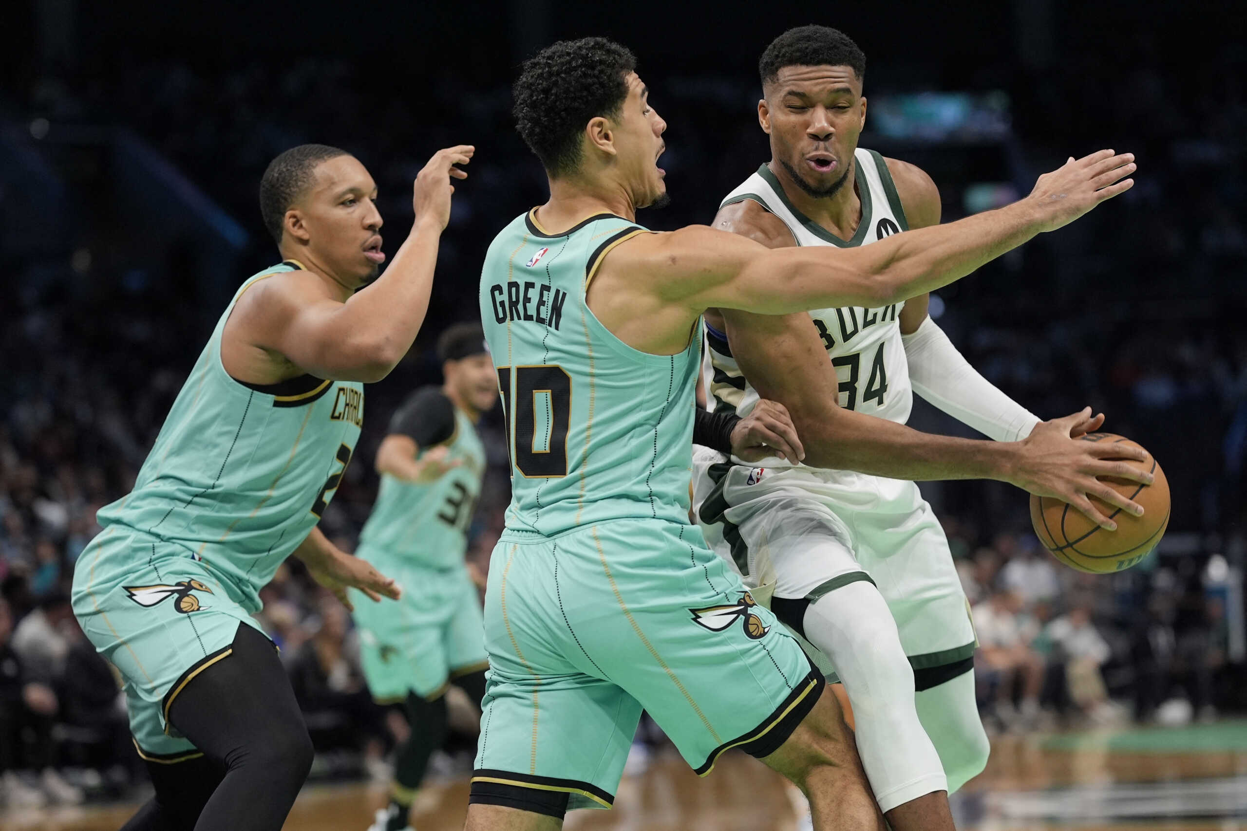 Nov 16, 2024; Charlotte, North Carolina, USA; Milwaukee Bucks forward Giannis Antetokounmpo (34) is pressured by Charlotte Hornets guard Josh Green (10) and forward Grant Williams (2) during the second quarter at Spectrum Center. Mandatory Credit: Jim Dedmon-Imagn Images