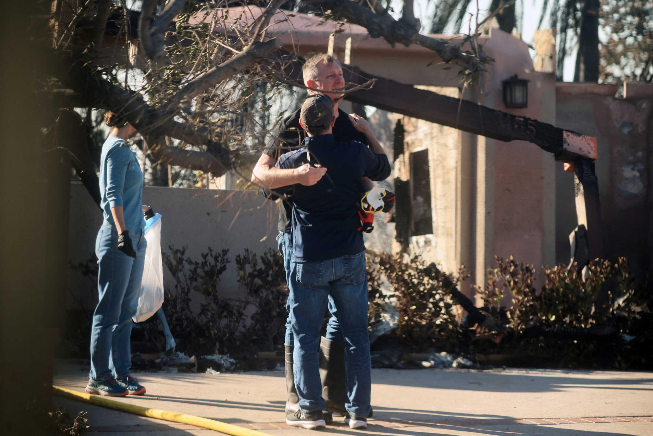 People react near houses that were damaged in the Mountain Fire in Camarillo, U.S., November 7, 2024. REUTERS